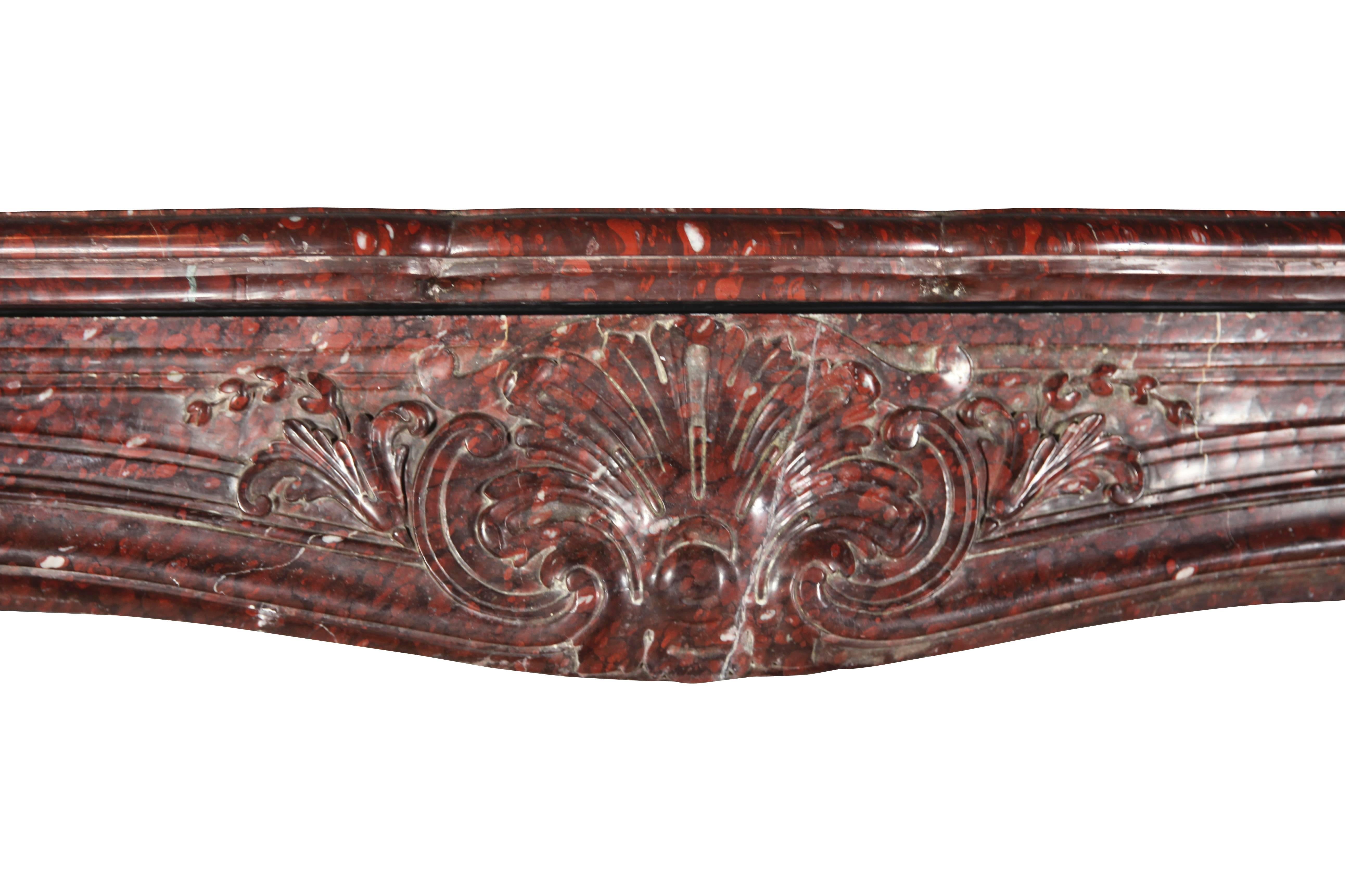 This Museum quality original antique fireplace mantle in Rouge Griotte marble was installed in Grand interior in Paris. It is a Regency Rococo style from the 19th century. The front is massive while carving is ultra delicate. A one of a kind piece