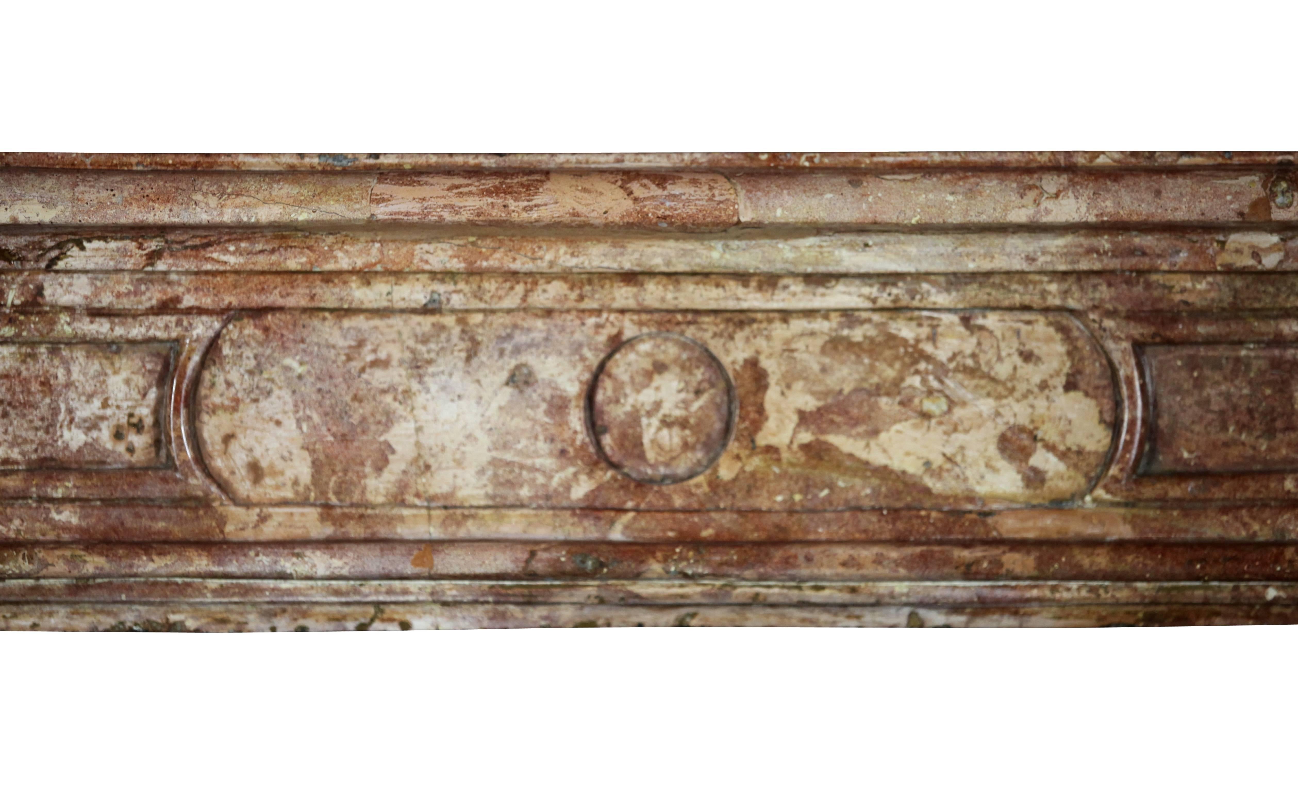 This mantel is an original French Burgundy surround in a Rose Liseron hard stone. 
Front piece was broken and is restored. Even if a trained eye can hardly see the formal damage it is always a serious decrease of the value. Remains a very
