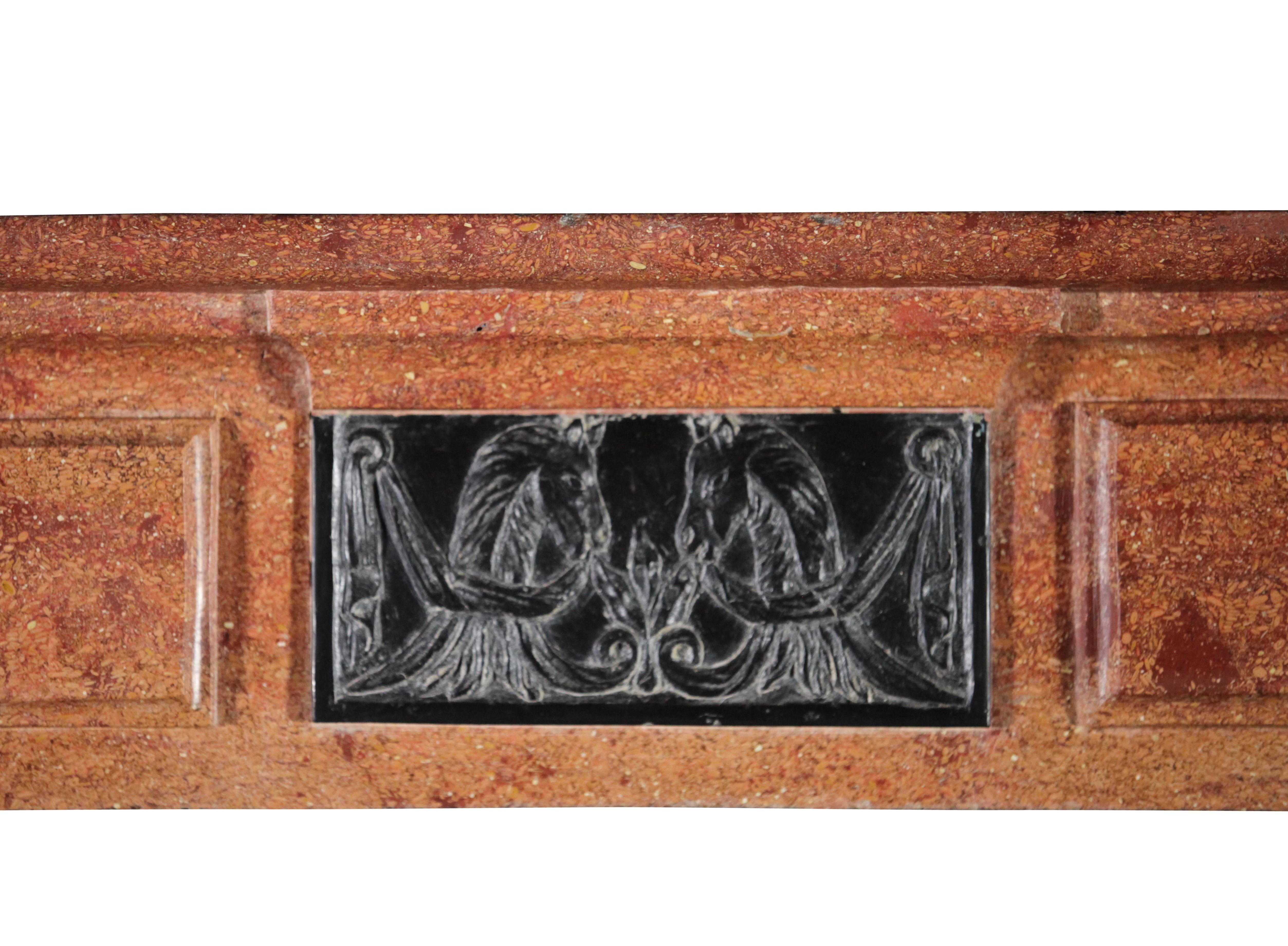 A phenomenal Directoire period fireplace mantel in hard stone with Black Belgian marble inlay. The centrepiece shows horse head details. The front is unusually bowed to the back of the wall. This gives this is an extra twist. This one was installed
