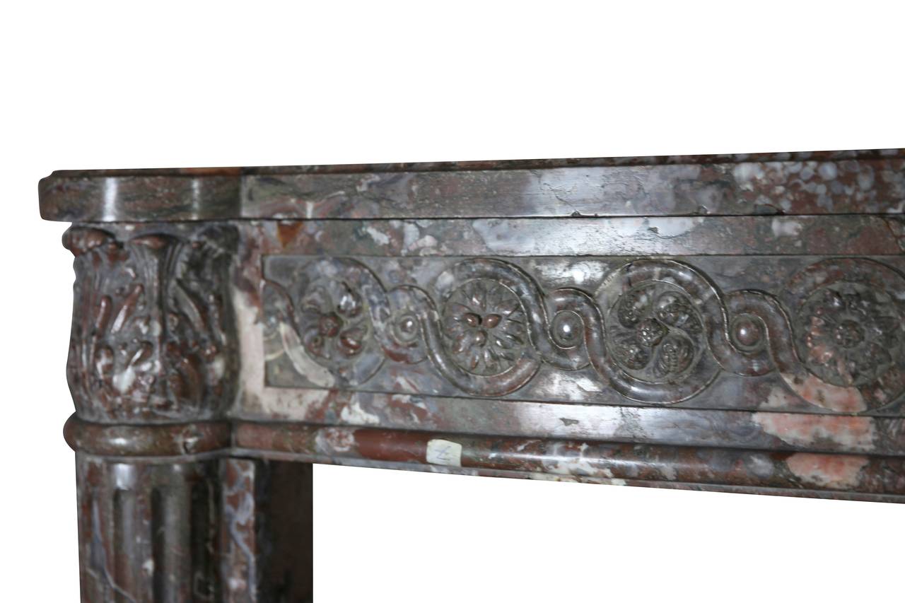 This is a very high end, one of a kind original fireplace surround in perfect condition. The fronton is one solid piece of marble. It is decorated with macarons; the carving is alive and fluid. It is from the Louis XVI period, second half of the