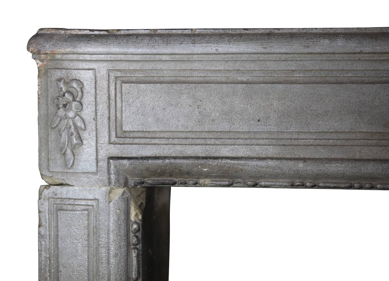 This is a very beautiful limestone fireplace surround still bearing its original grey patina. It is in perfect condition and not broken. This mantel was installed in a paneled room. Would work too in a Directoire style interior. A vintage element to