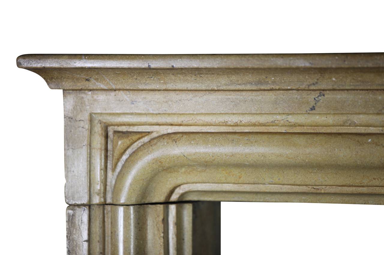 A honey warm color surround for a square firebox. This small fireplace surround is from the city of Dijon, France. It is constructed in the Louis XIV style and dates from the 19th century. This mantle is made of Burgundy hard stone in three solid