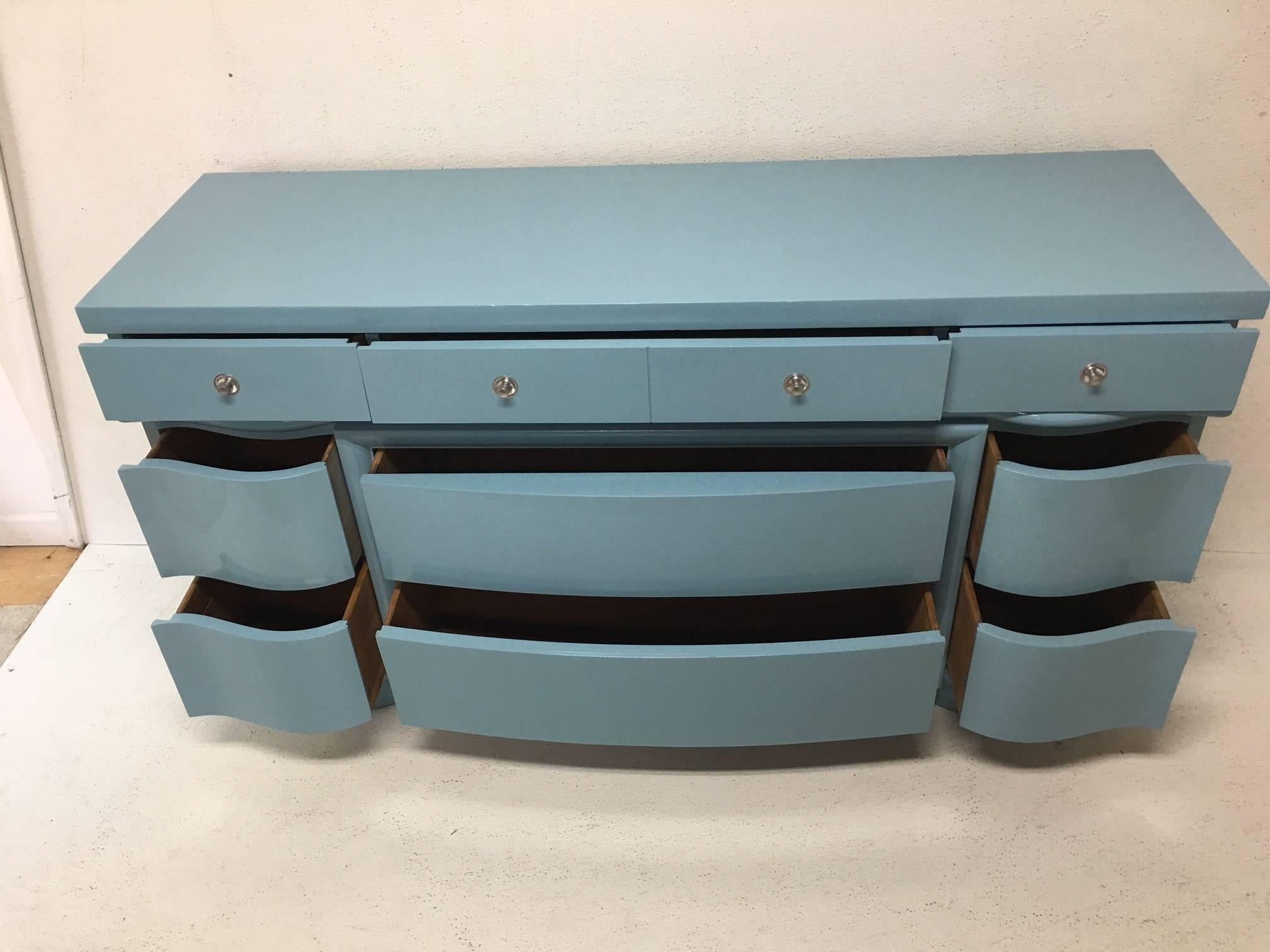 This vintage Dixie dresser has great curve appeal and provides excellent storage. Lacquered and sealed in a Robin's egg color, it is perfect for bedroom, nursery, foyer, coastal home. Simple MCM styling with silver hardware. A gorgeous piece.