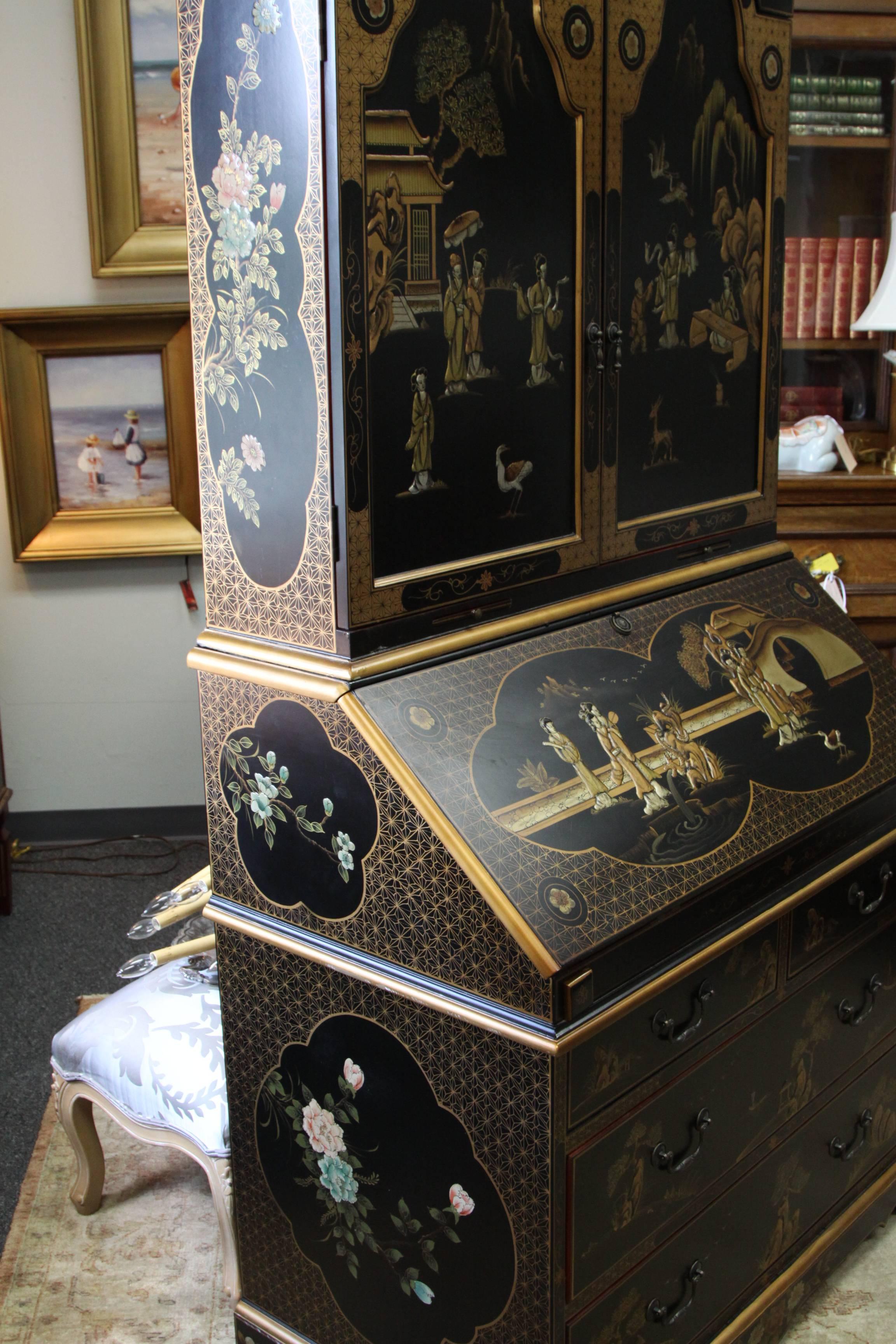 Dramatic Maitland Smith Queen Anne style secretary desk with plenty of work space, organizing compartments and storage. Featuring a deep Black lacquered finish decorated with chinoiserie style painted oriental scene and with gilt.. Having a broken