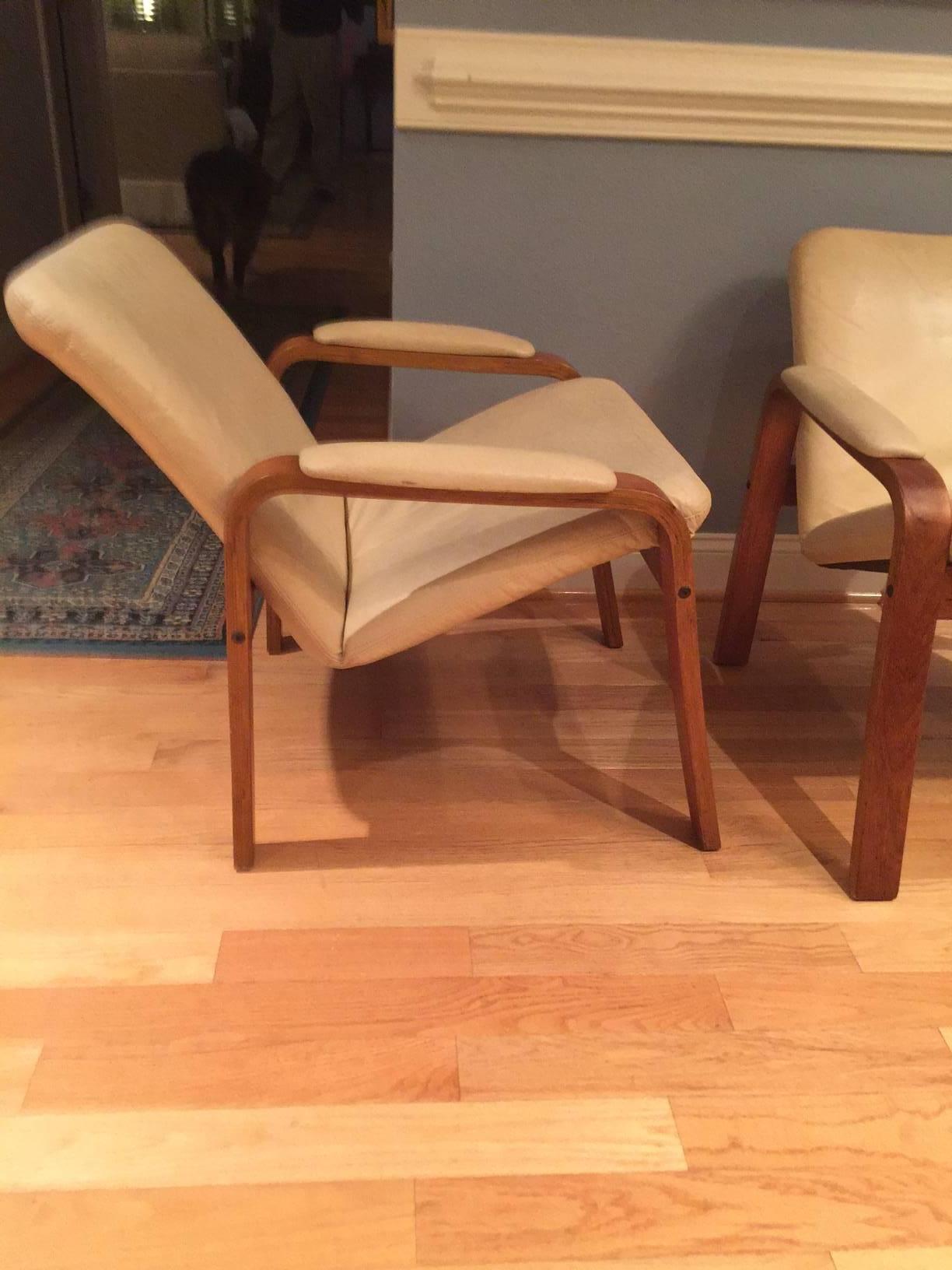 This pair of Ekornes lounge or armchairs are produced by J.E. Ekornes, circa 1970s, in Norway. The frames are solid teak and in excellent condition. The leather is showing signs of wear. Ekornes ASA is the largest furniture manufacturer in the