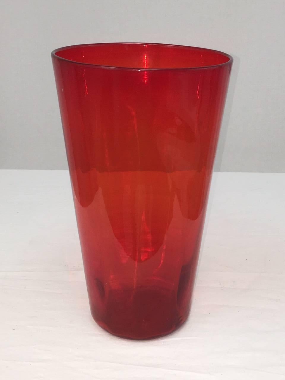 This collectable vase by Blenko is a deep red-orange. It is blown glass by famous maker Blenko. Brilliant color. Measures: 7" at mouth; 4.5" at base.