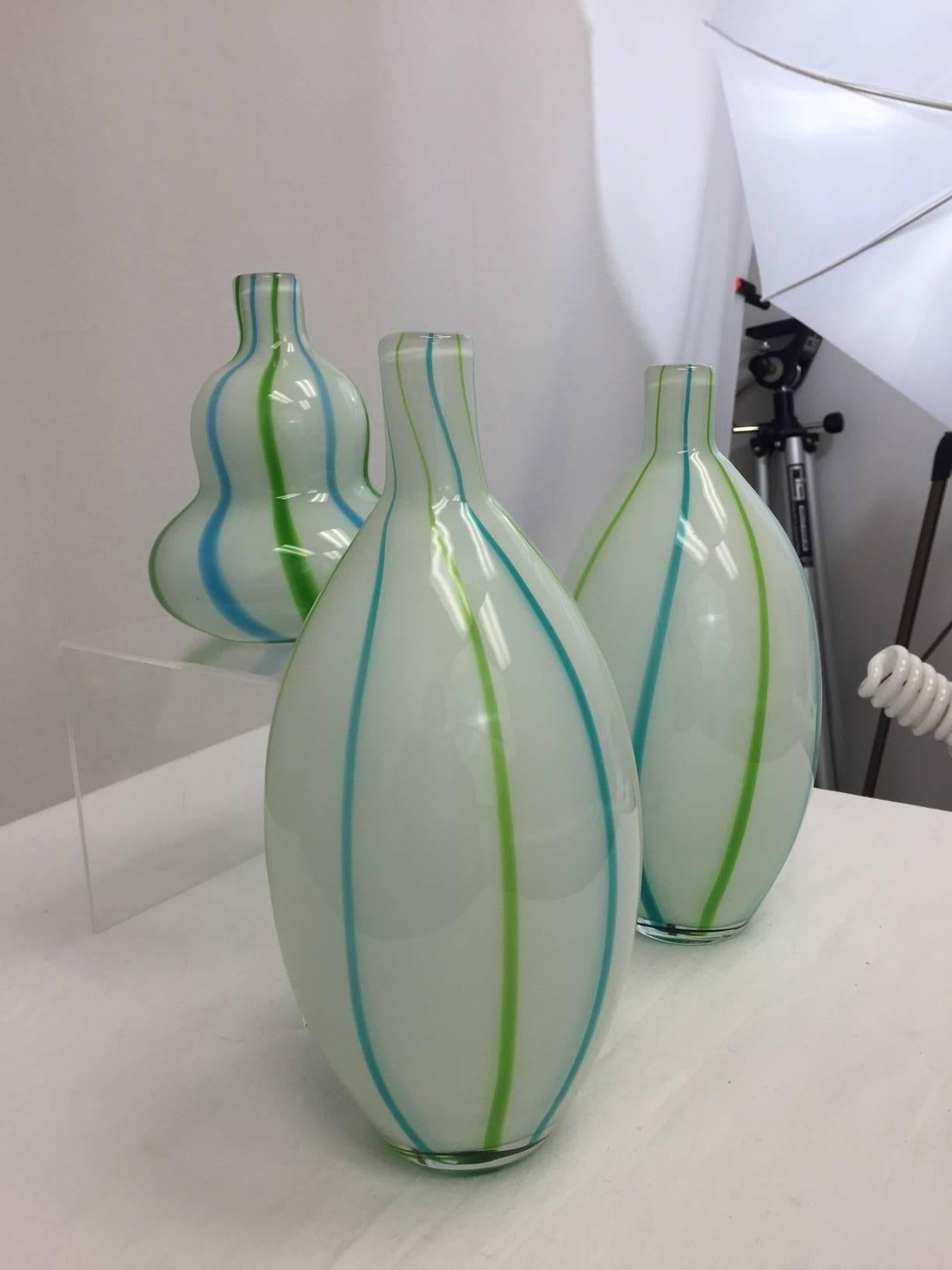 Trio of three Murano vases with grass green and turquoise stripes on opaque white glass. Measures: The tallest is 11