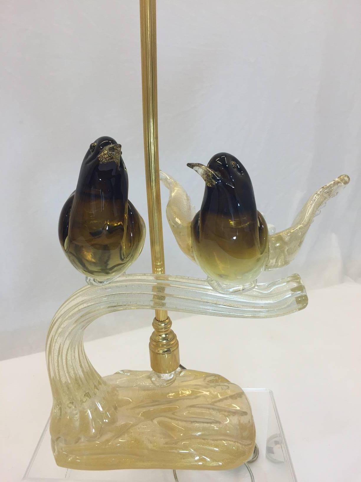 This precious pair of brown and butterscotch birds are perched a top a golden branch emanating from an organic glass nest. This unique lamp is marked Murano and is undoubtedly a one-of-a-kind. Gold accents.