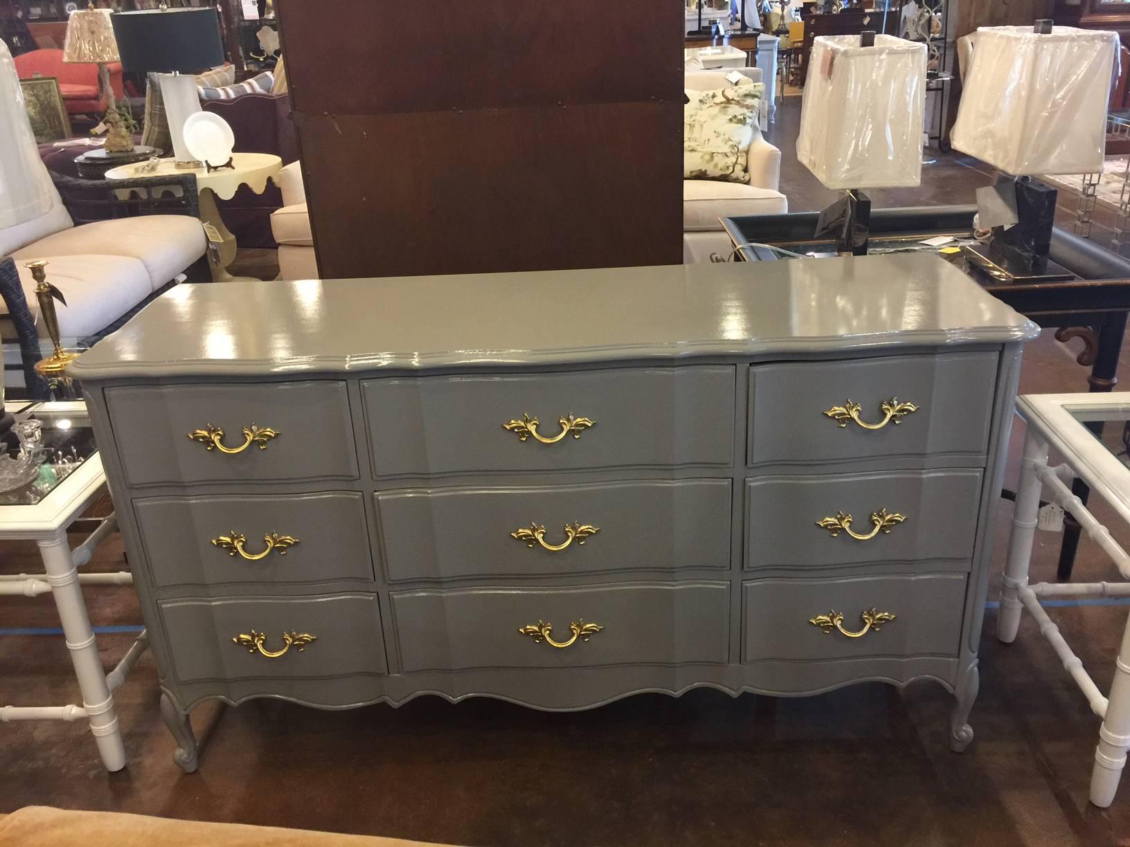 This vintage Dixie dresser can also serve a credenza in a living or dining room. Nine drawers provide plenty of storage. The piece has been professionally lacquered in a BM gray and the hardware has been gilded. The curvy lines provide a French feel.