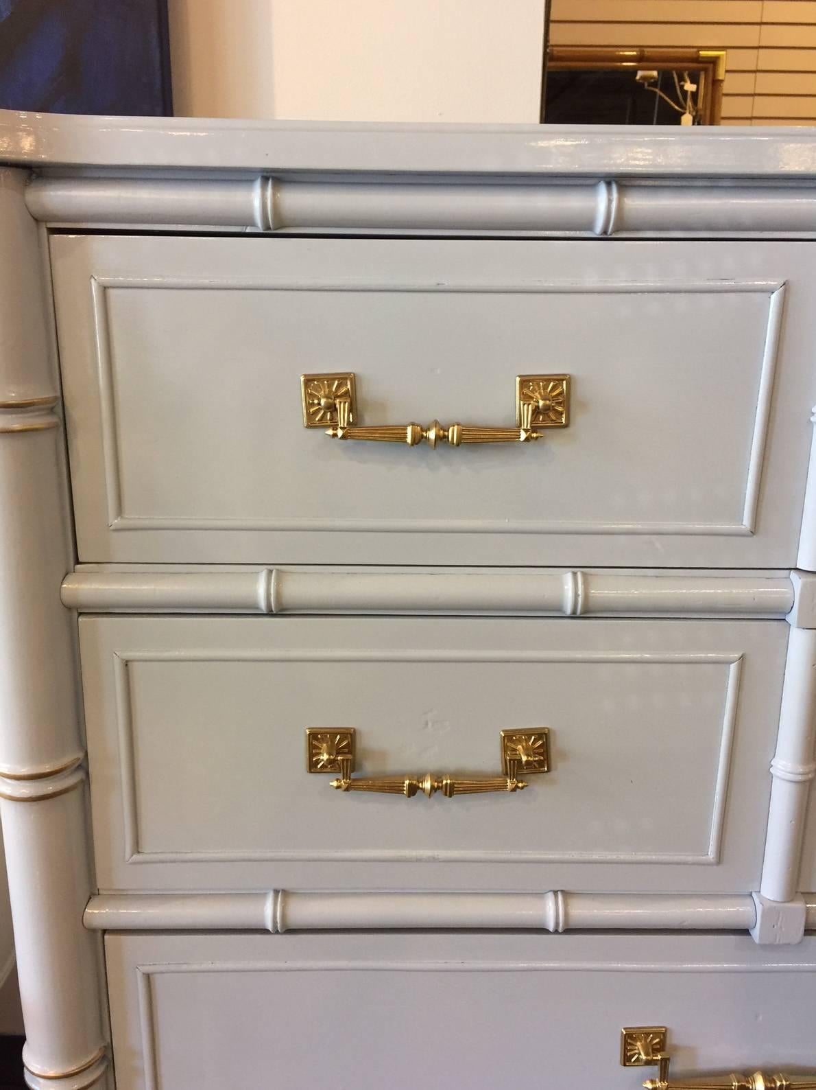 This vintage faux bamboo chest has been given new life with professional lacquer in a high gloss BM shade of gray with a hint of light blue. It has been trimmed in gold and is ready to grace your home. Henry Link for the Bali Hai