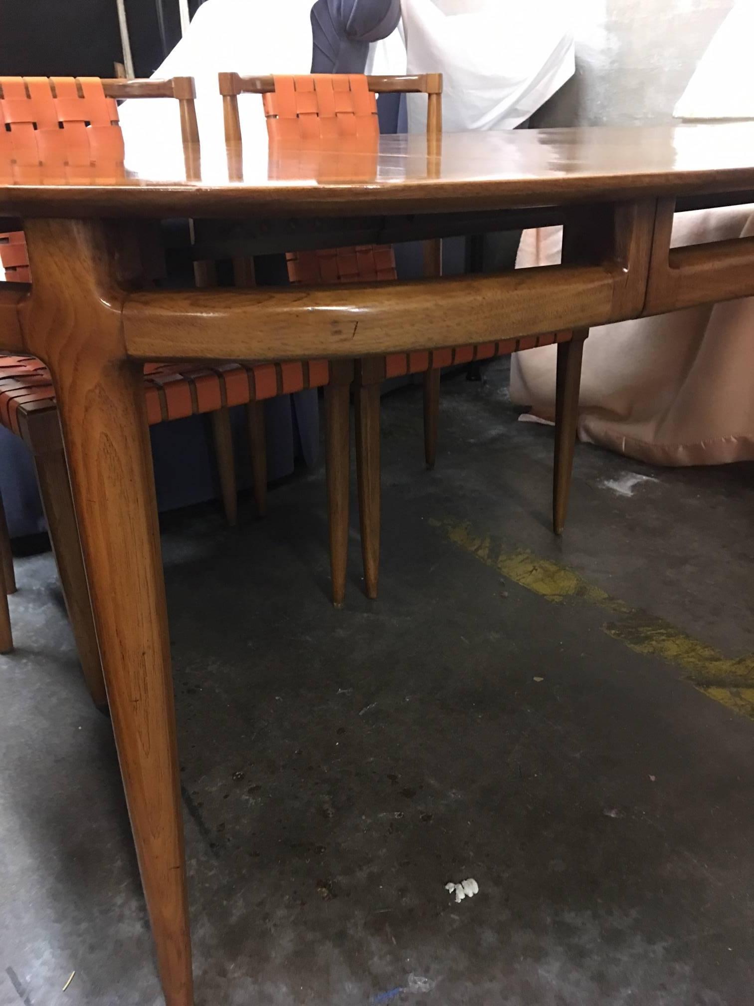 This maple table is in great vintage condition with minor signs of wear. A lovely Mid-Century design with a leaf insert providing an accent pattern. This piece has 6 chairs that go with it featured in a separate listing. Made by and marked Tomlinson