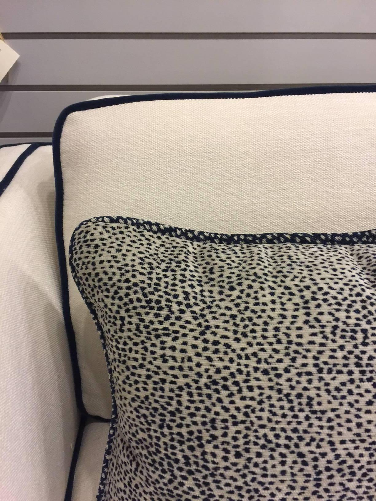 This vintage sofa has new cushions and new upholstery. The off-white upholstery has been accented with navy mohair cording. It is a crisp look, and sits quite comfortably. 

The blue and cream pillows shown in some photos have been sold.