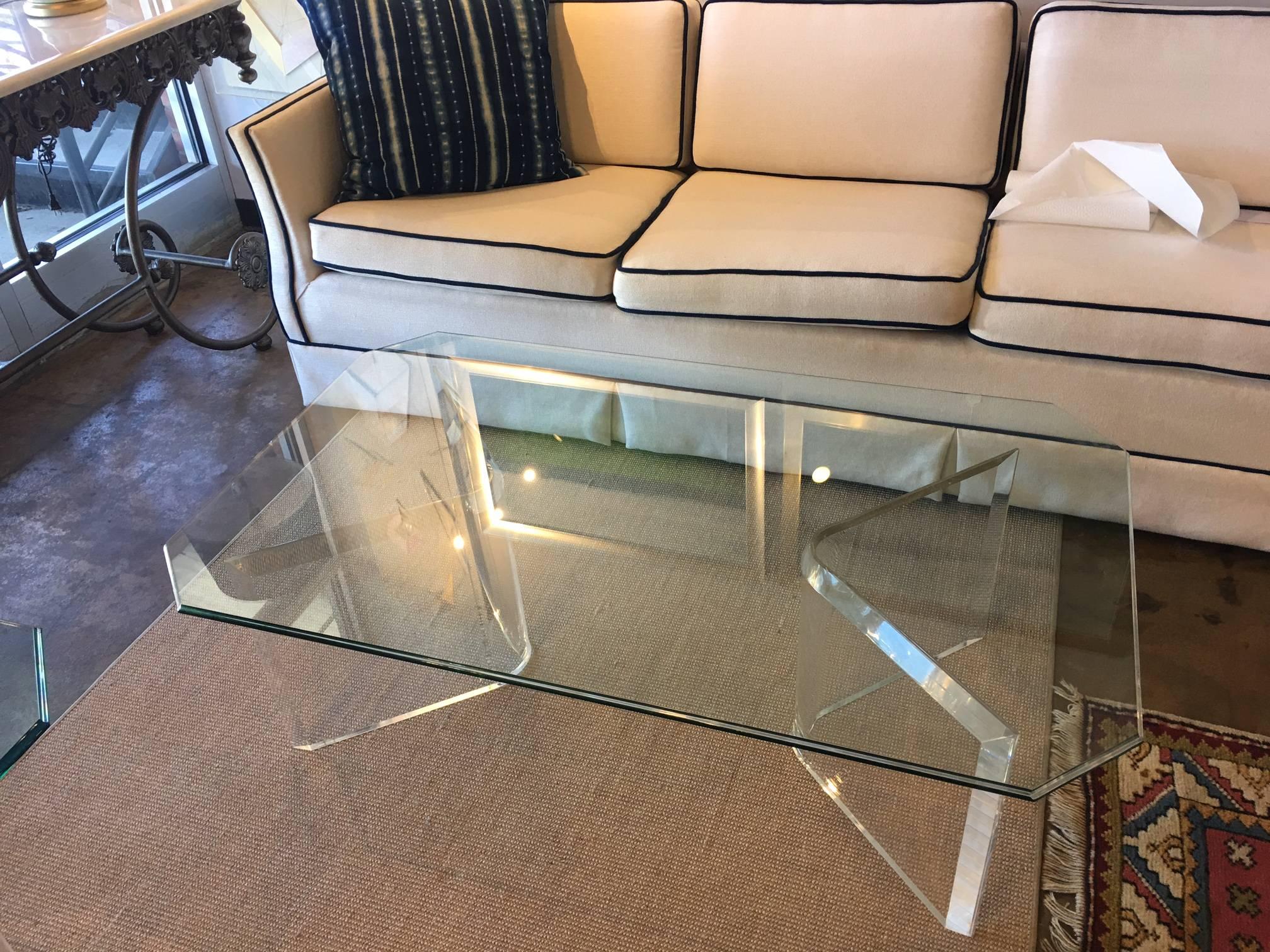 This modern coffee table is in excellent vintage condition. It has been in storage (covered) for a decade and probably hales from the 1970s. The Lucite bases can be configured facing either way and can be placed at different angles and distances. We