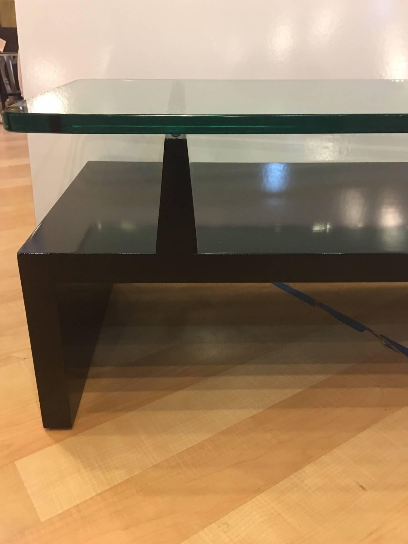 This is a signed piece by Tommi Parzinger for Parzinger originals and has been recently lacquered gloss black. It is in excellent condition with an incredible deep glass top with rounded edges. The glass is nearly an inch thick. A beautiful piece.