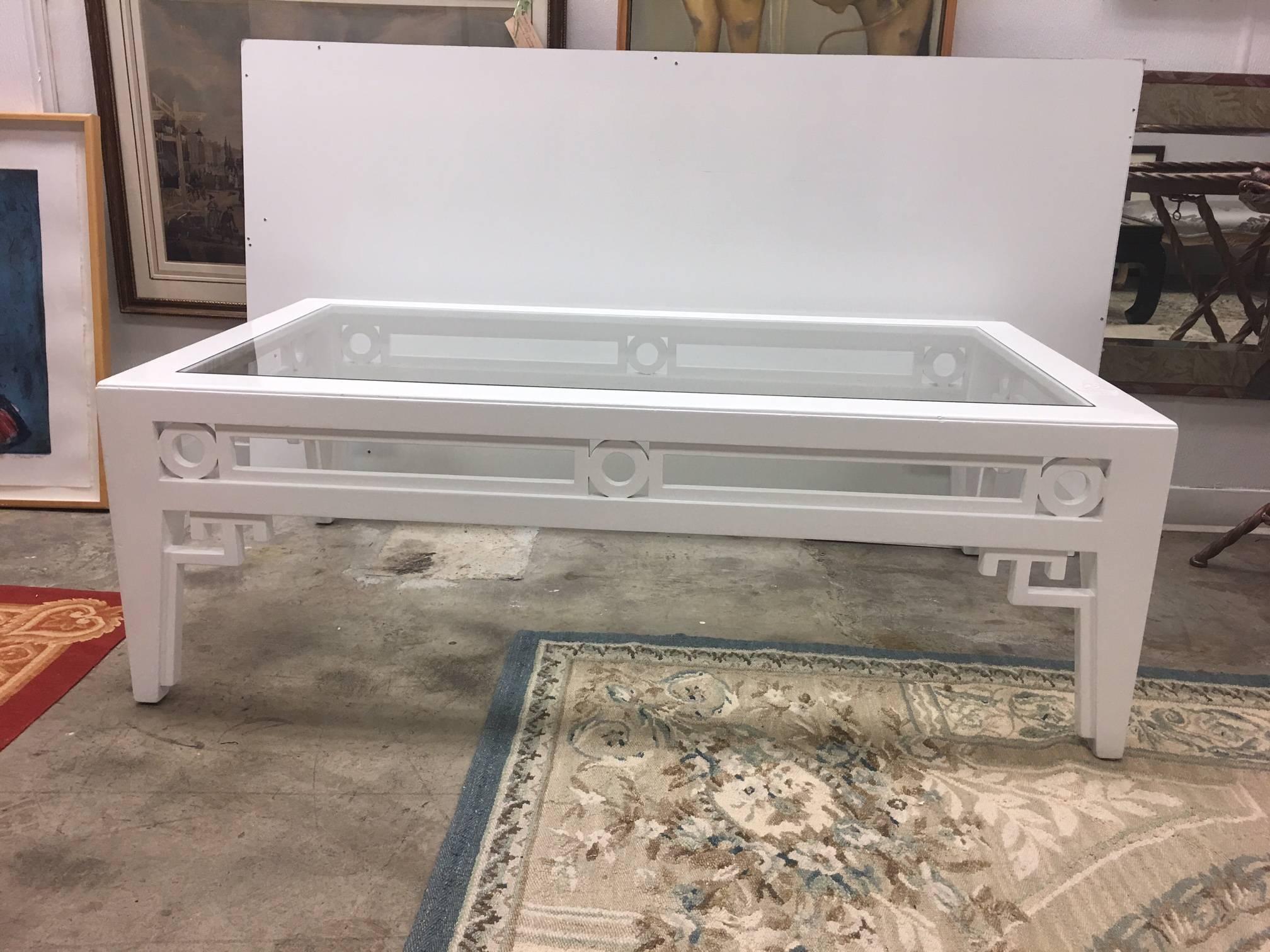 This piece a very large coffee table with neoclassical accents. It has recently been lacquered professionally in high glass alabaster. Signs of some distressing remain and the piece is not perfectly smooth. The piece is priced accordingly, with