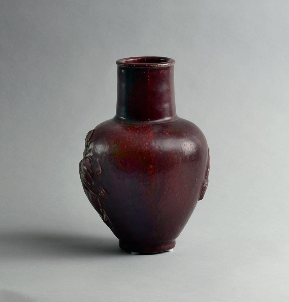 Stoneware vase with relief decoration of "The Potter" with oxblood glaze.