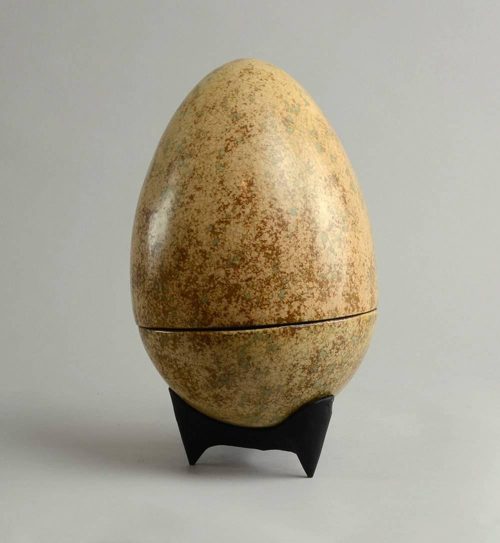 Hans Hedberg, own studio, Biot, France
Unique stoneware egg with peach, pale green and brown crackle glaze, on iron tripod stand.
Height (on stand) 12