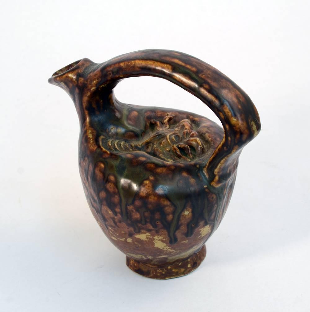 Unique stoneware jug with stylized crustacean in relief to top and dripping brown glaze, circa 1930s.