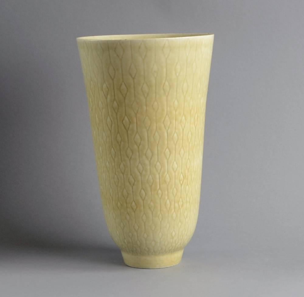 Large stoneware vase with matte beige crystalline glaze with carved line pattern to exterior.
Incised 