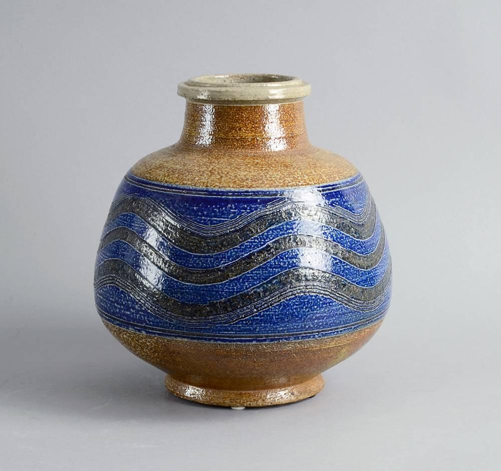 Nils Kähler for Kähler Keramik, Chamotte stoneware vase with incised horizontal patterns ad glossy transparent glaze over blue and brown underglaze, 1950s-1960s.
Height 9 1/2