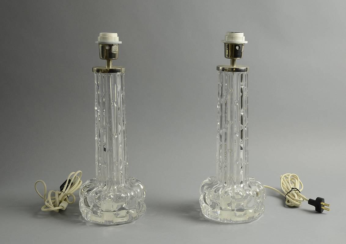 Pair of clear glass table lamps, by Carl Fagerlund for Orrefors.
Height to top of socket 17" (43cm), width 6" (15 cm).
Mark obscured by base.
Excellent condition, no chips, cracks or repairs.