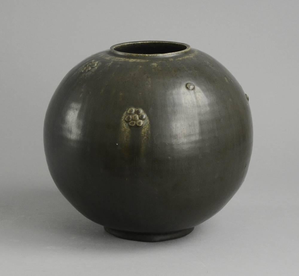 Arne Bang, own studio, Denmark.
Stoneware large spherical vase with applied rosettes, matte charcoal grey haresfur glaze, 1930s.
Measures: Height 8 1/2
