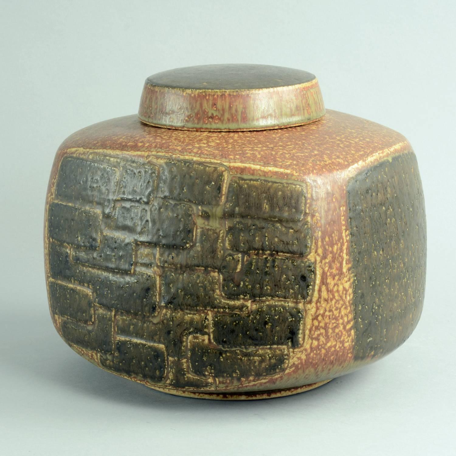 Eva Staehr Nielsen for Saxbo, Denmark

Large lidded vessel in chamotte stoneware with mottled reddish brown and dark brown glaze, pattern of overlapping rectangles in light relief to front and back, circa 1960s.
Measures: Height 9 1/2