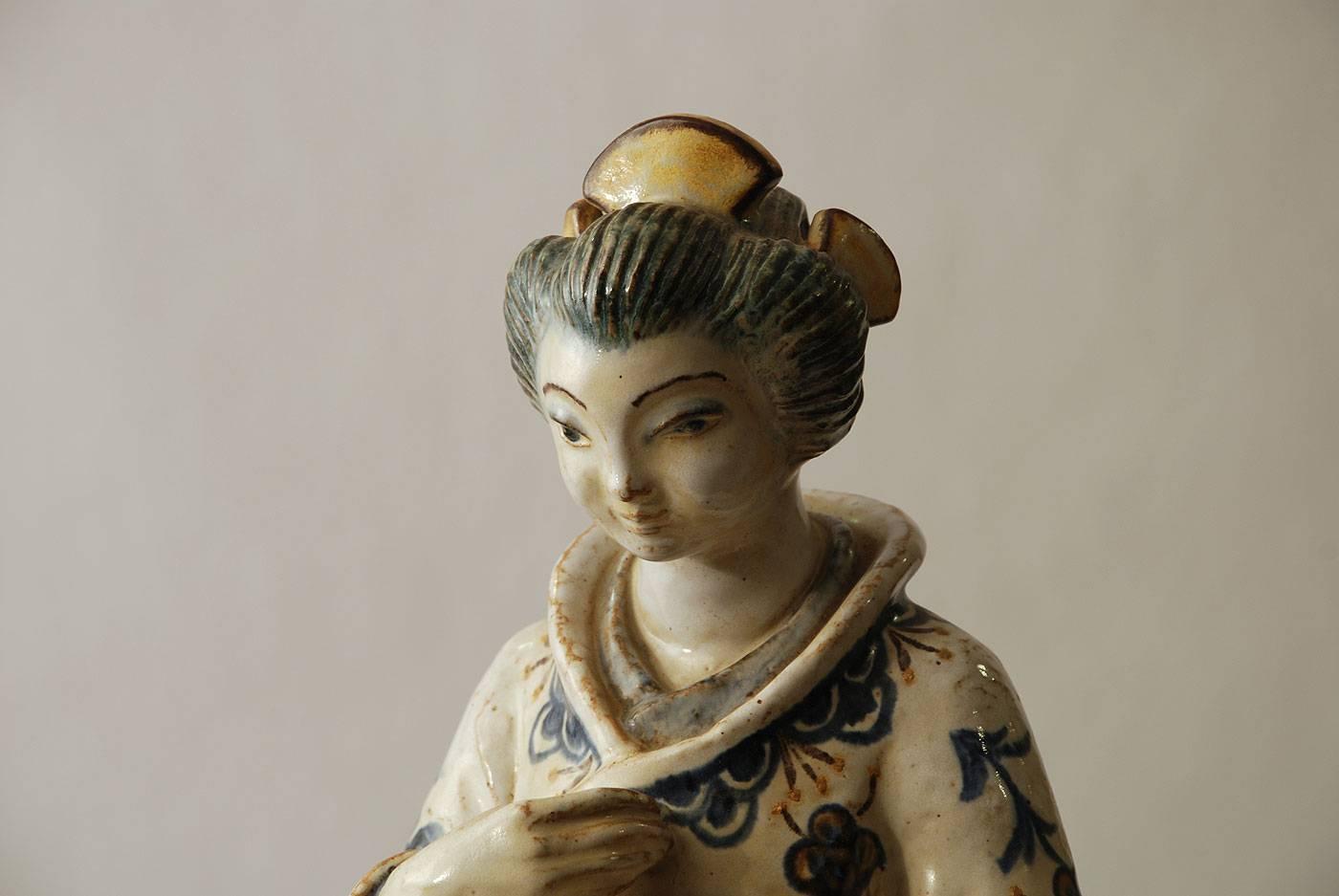 L. Hjorths terracotta fabric

Unique stoneware sculpture of a Japanese woman with semi-gloss glaze in cream, blue and brown.
Impressed "L Hjorth", Stag.
Measures: Width 10" (26cm) 
height 21" (53 cm)
Excellent condition, no
