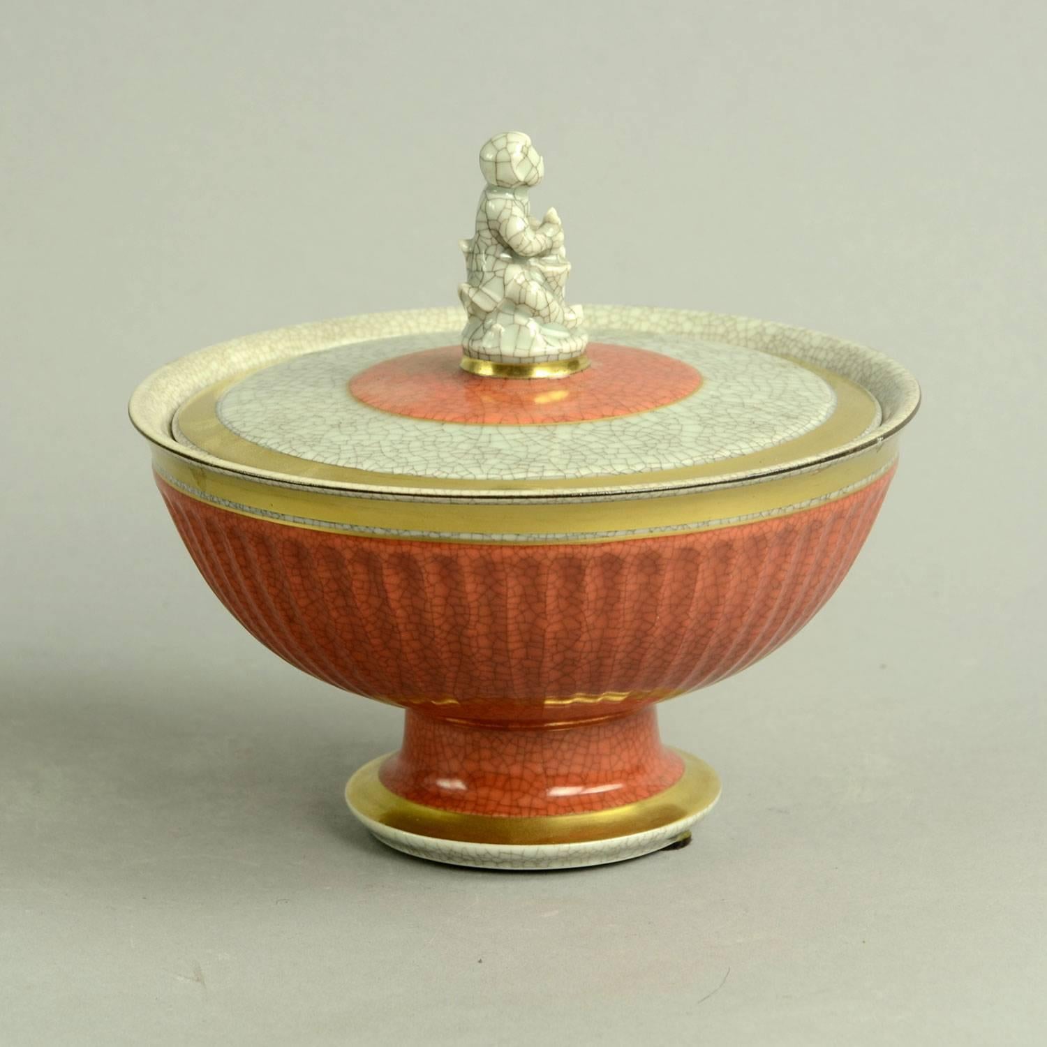 Porcelain lidded, footed bowl with figure of a child and dove to lid, gray and orange crackle glaze with gold leaf, 1950s-1960s.
Measures: Height 5 1/2" (14 cm), width 6" (15 cm) 
Excellent condition, no chips, cracks or repairs.