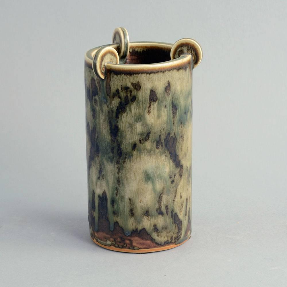 Arno Malinowski for Royal Copenhagen, Denmark

Stoneware cylindrical vase with applied discs to rim, Sung glaze, 1940s.
Painted 