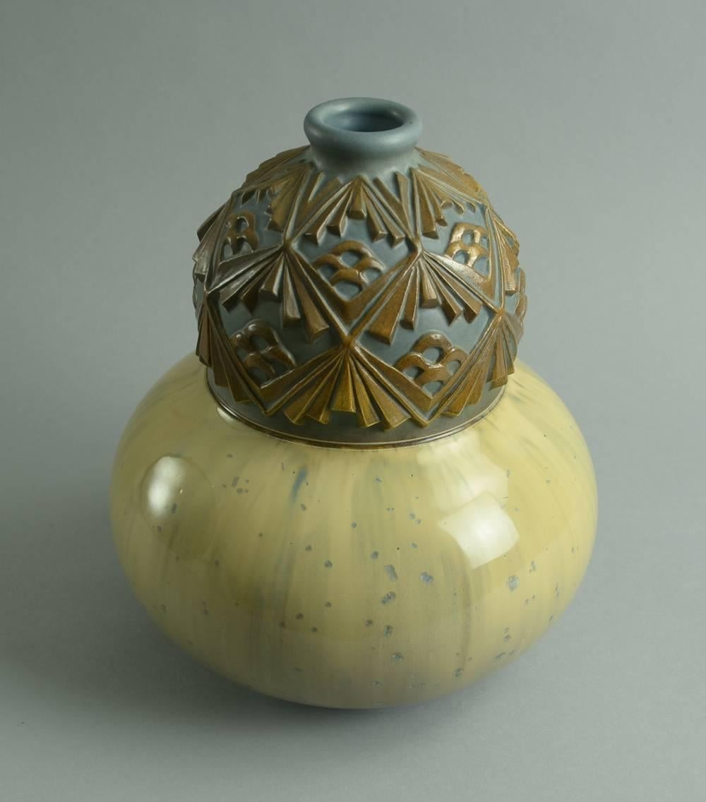 Stoneware vase with carved relief decoration and matte blue, matte brown and glossy yellow glazes.