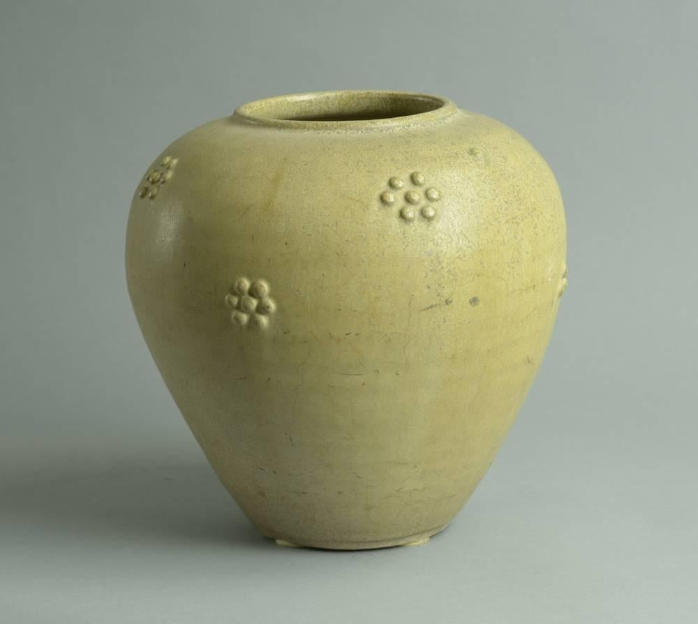 Stoneware vase with applied rosette decoration and matte beige glaze.