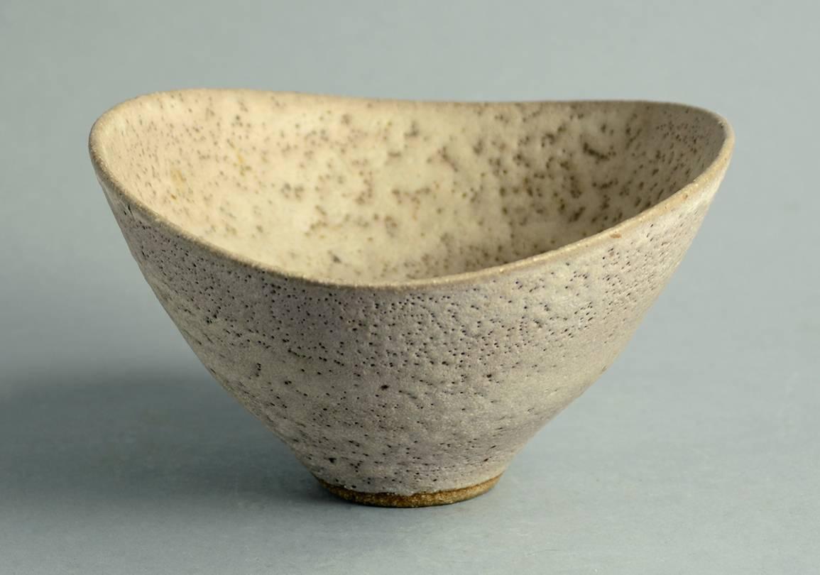 Unique stoneware bowl with matte pale brown pitted glaze.