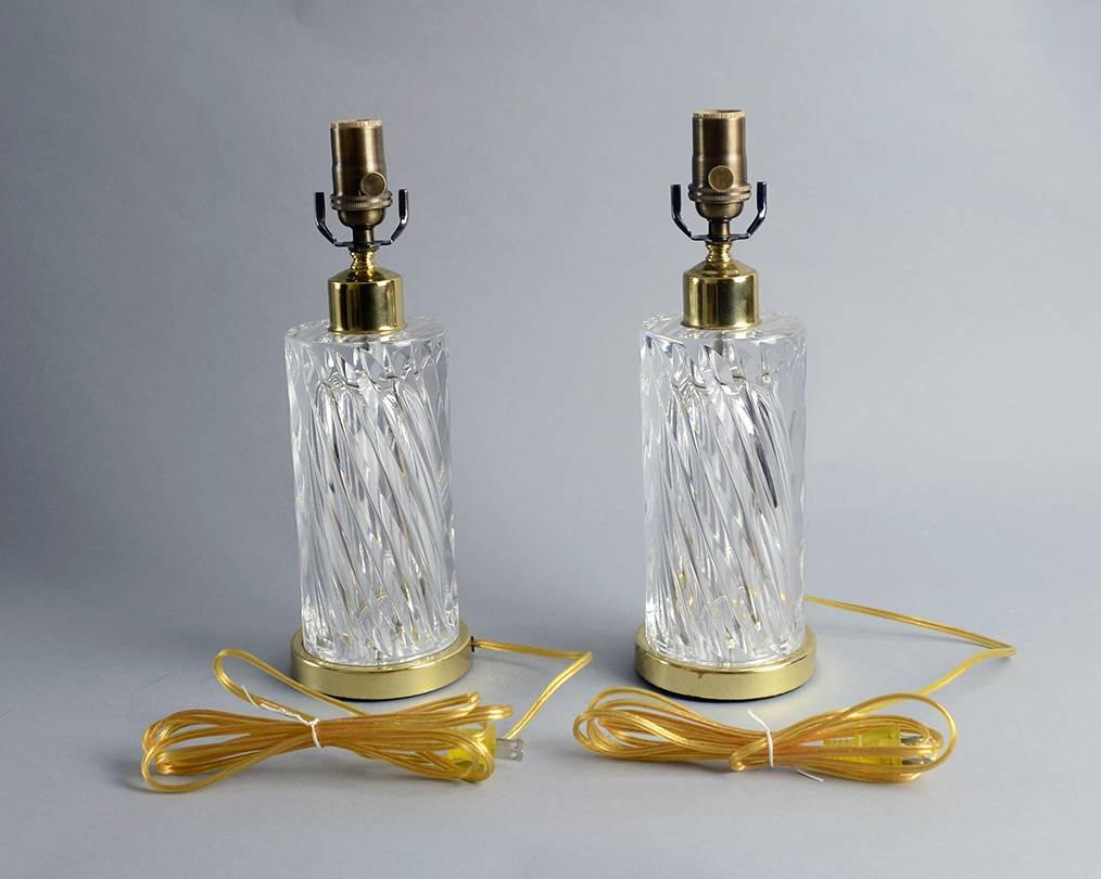 Pair of clear glass lamps with gold colored brass base.