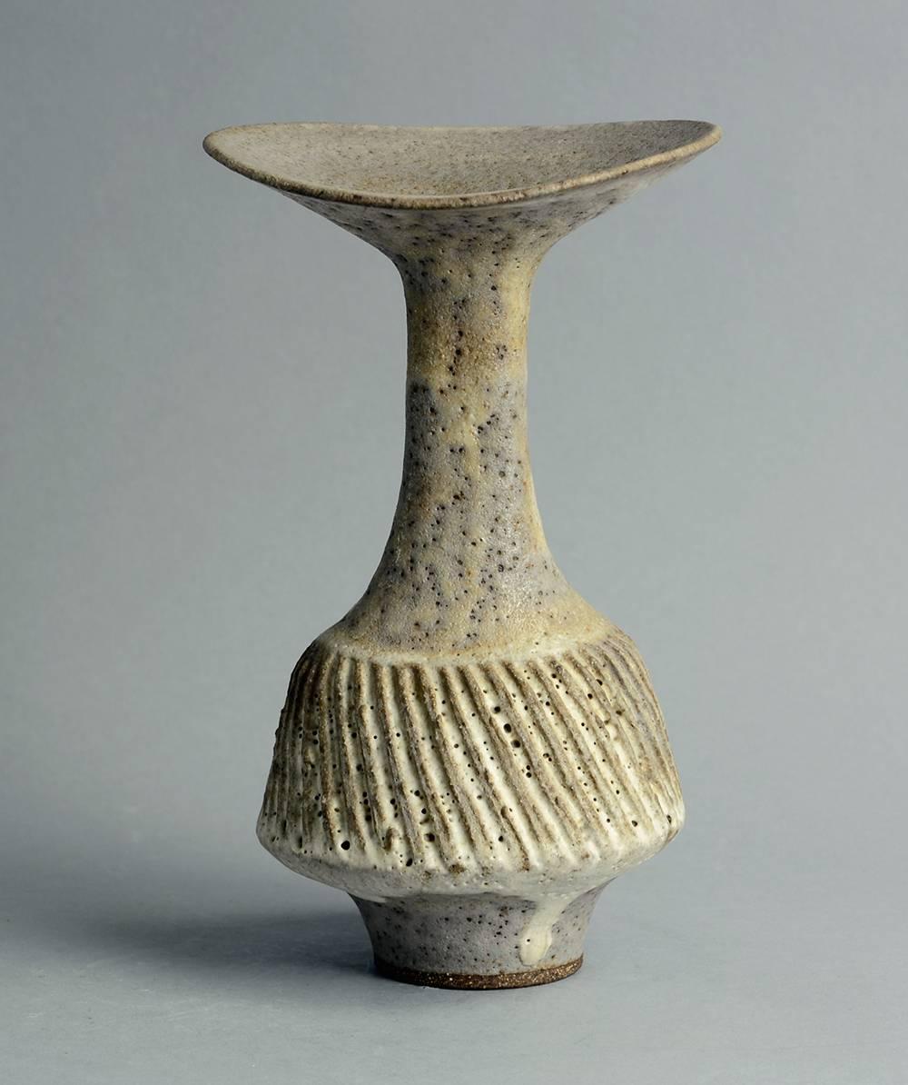 Unique stoneware vase with carved pattern to body and brown and off-white volcanic glaze.