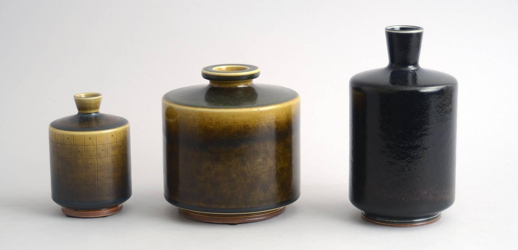 1. Unique stoneware vase with glossy pitted black glaze, 1965.
Height 7 1/4" (18.5 cm) Width 4" (10 cm)  No. N2591 
2. Unique stoneware bottle vase with glossy yellow and black glaze, with a grid pattern to body, 1962.
Height 4