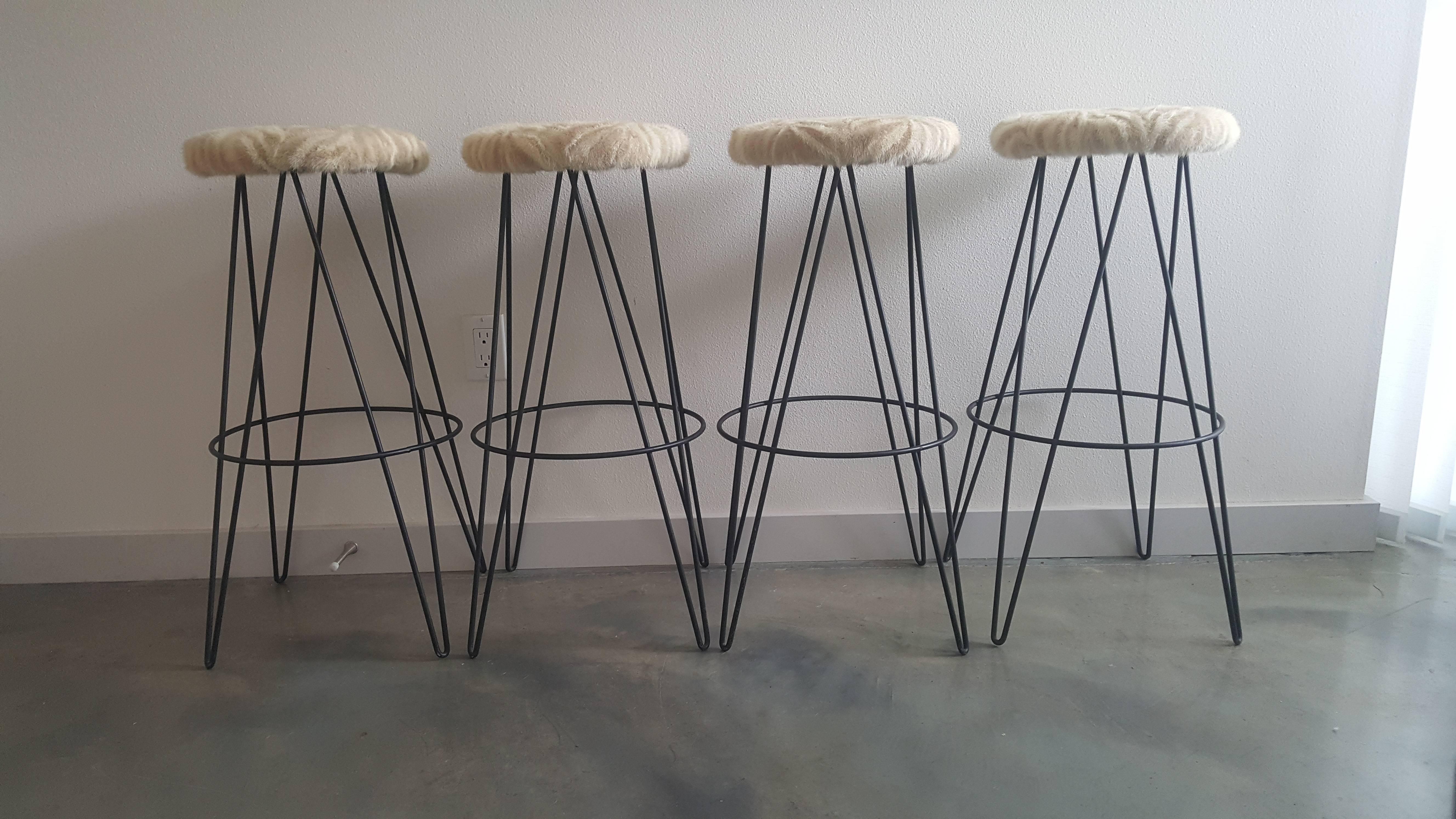 A stunning set of four rare thinline of California iron hairpin bar stools upholstered in a vintage chevron patterned cream and white mink fur.