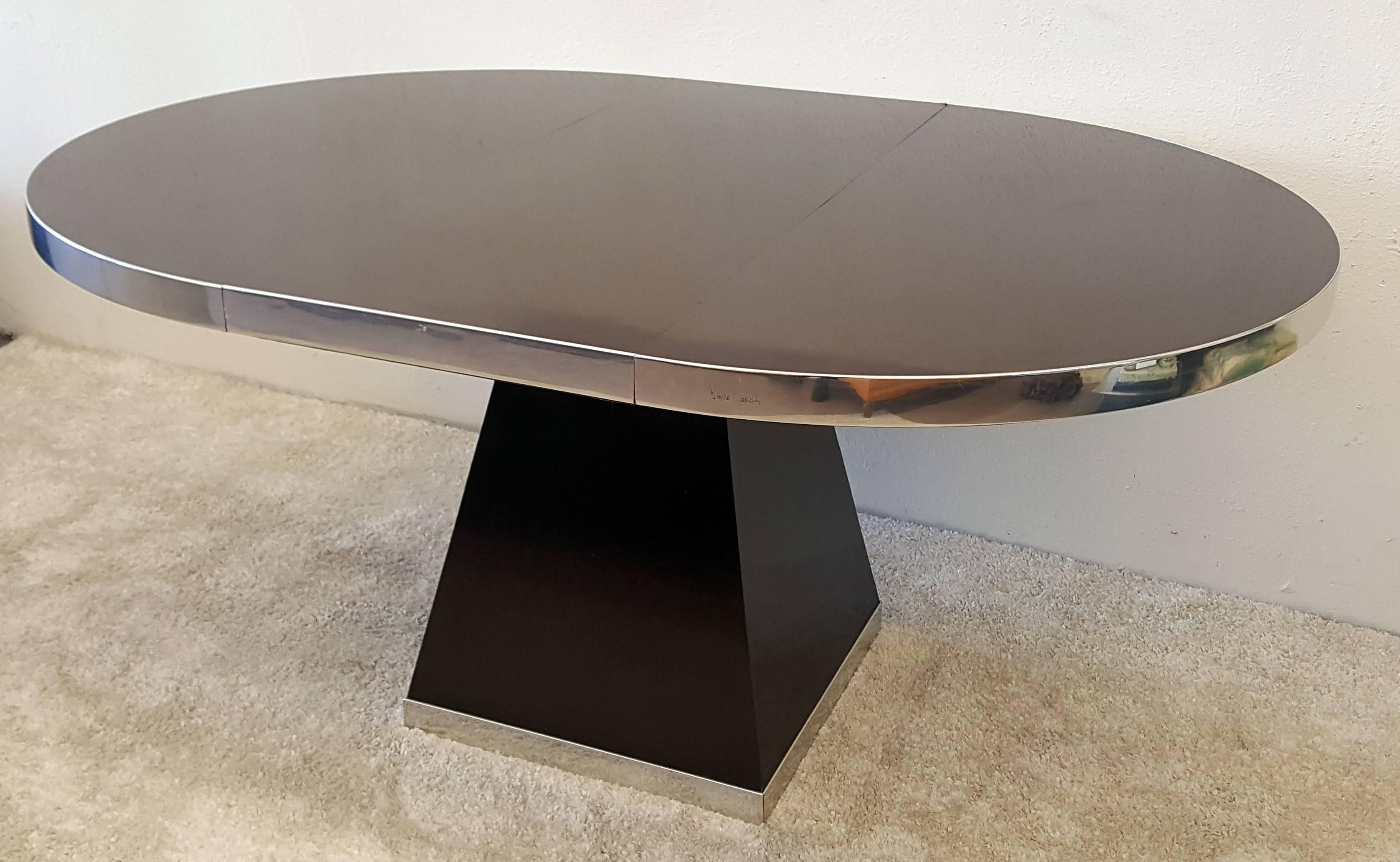 A chocolate colored laminate and polished chrome dining table by Pierre Cardin. This table measures: 45.5 in Diameter without leaf.