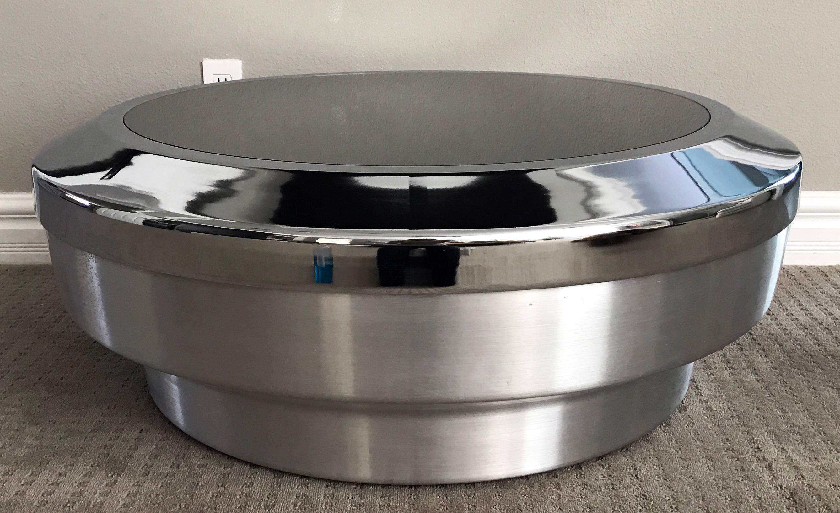 A stunning round, drum/canister coffee table designed by GJ Neville. Often attributed to Mastercraft, this stunning coffee table features a brushed chrome base, with polished chrome outer top and mirrored round top. The table is equal parts mid