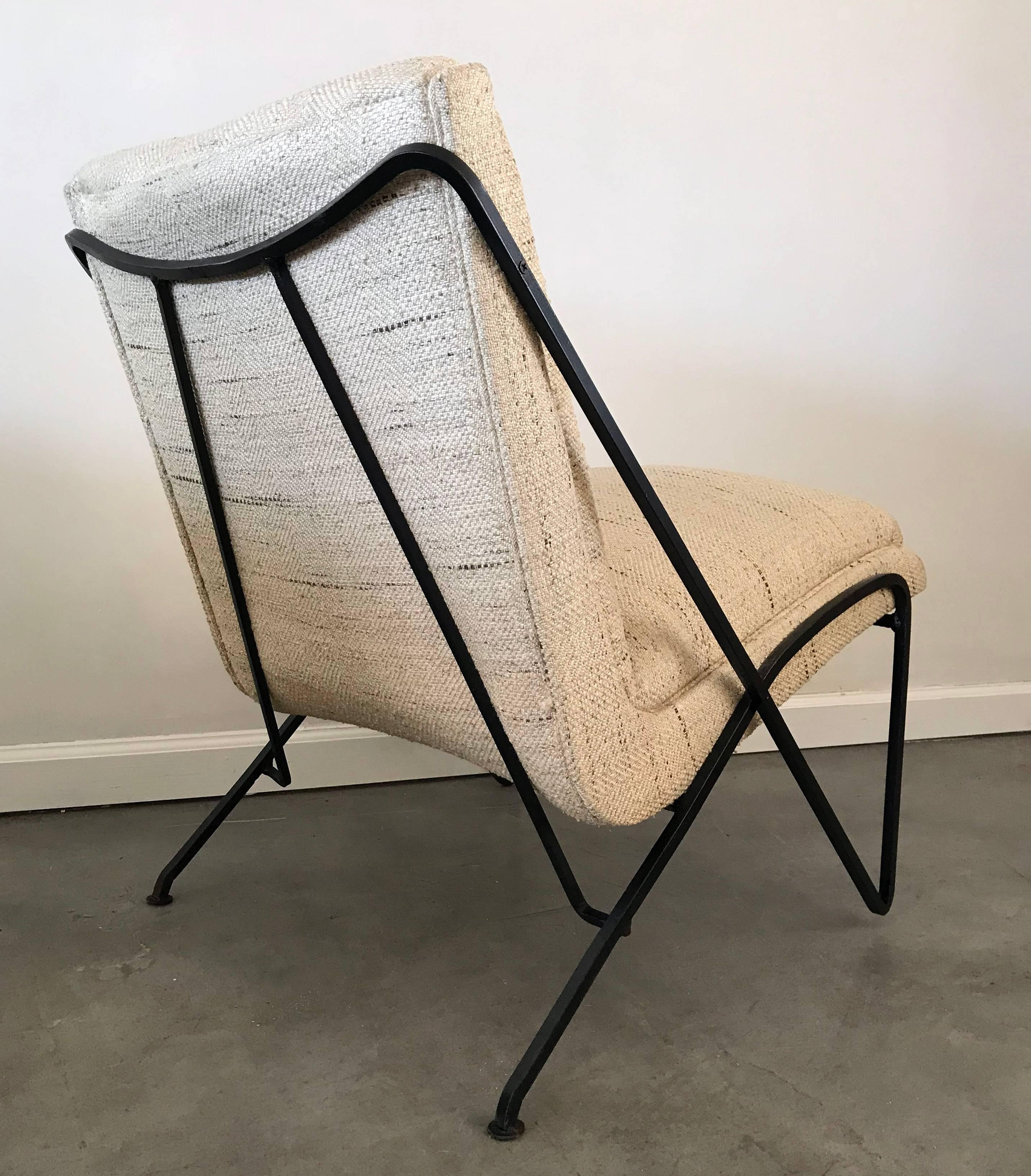 An absolutely gorgeous lounge chair by Maurizio Tempestini for Salterini. The lounge chair has a wrought iron frame with hairpin / paperclip style legs and has been ebonized in a satin black. The chair itself still retains its original oatmeal