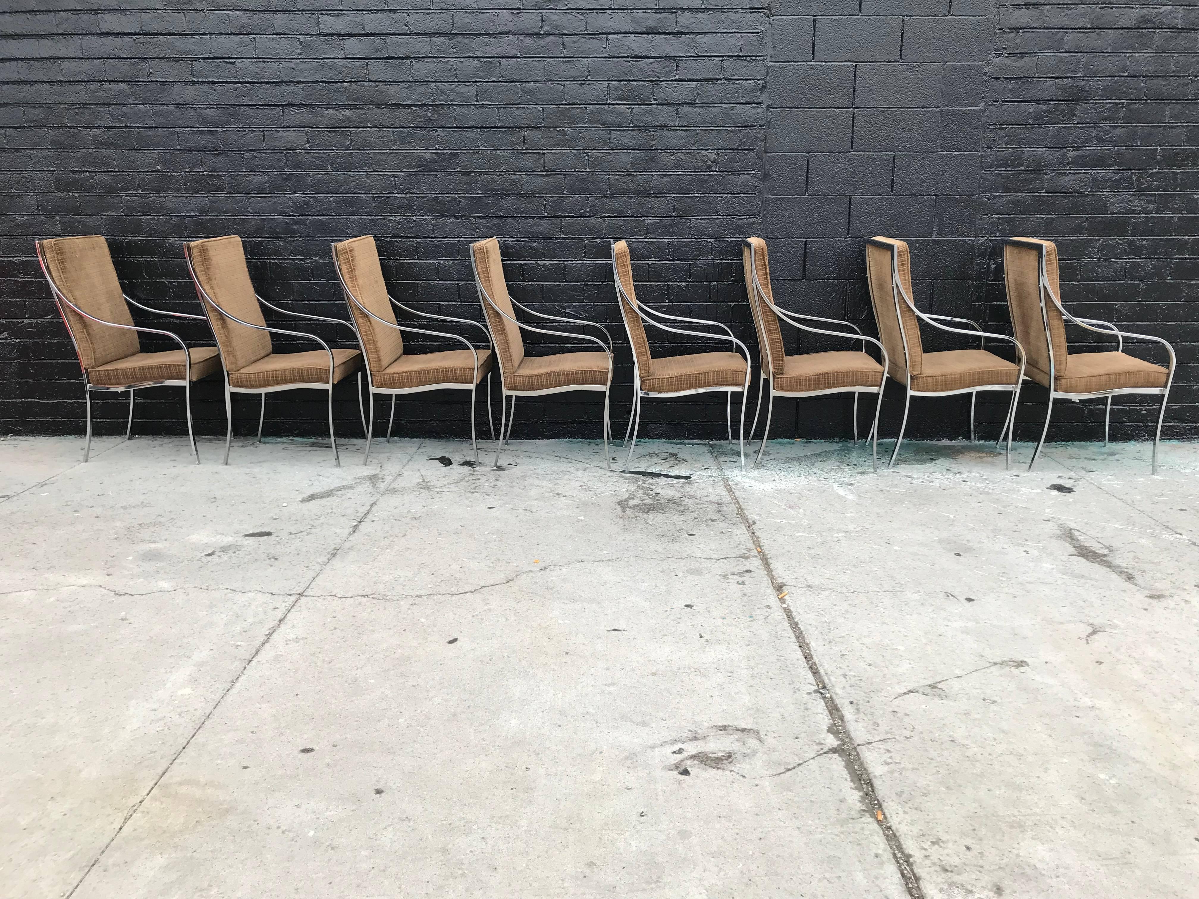 A stunning set of eight chrome and velvet dining chairs that feature a geometric pattern on fabric.