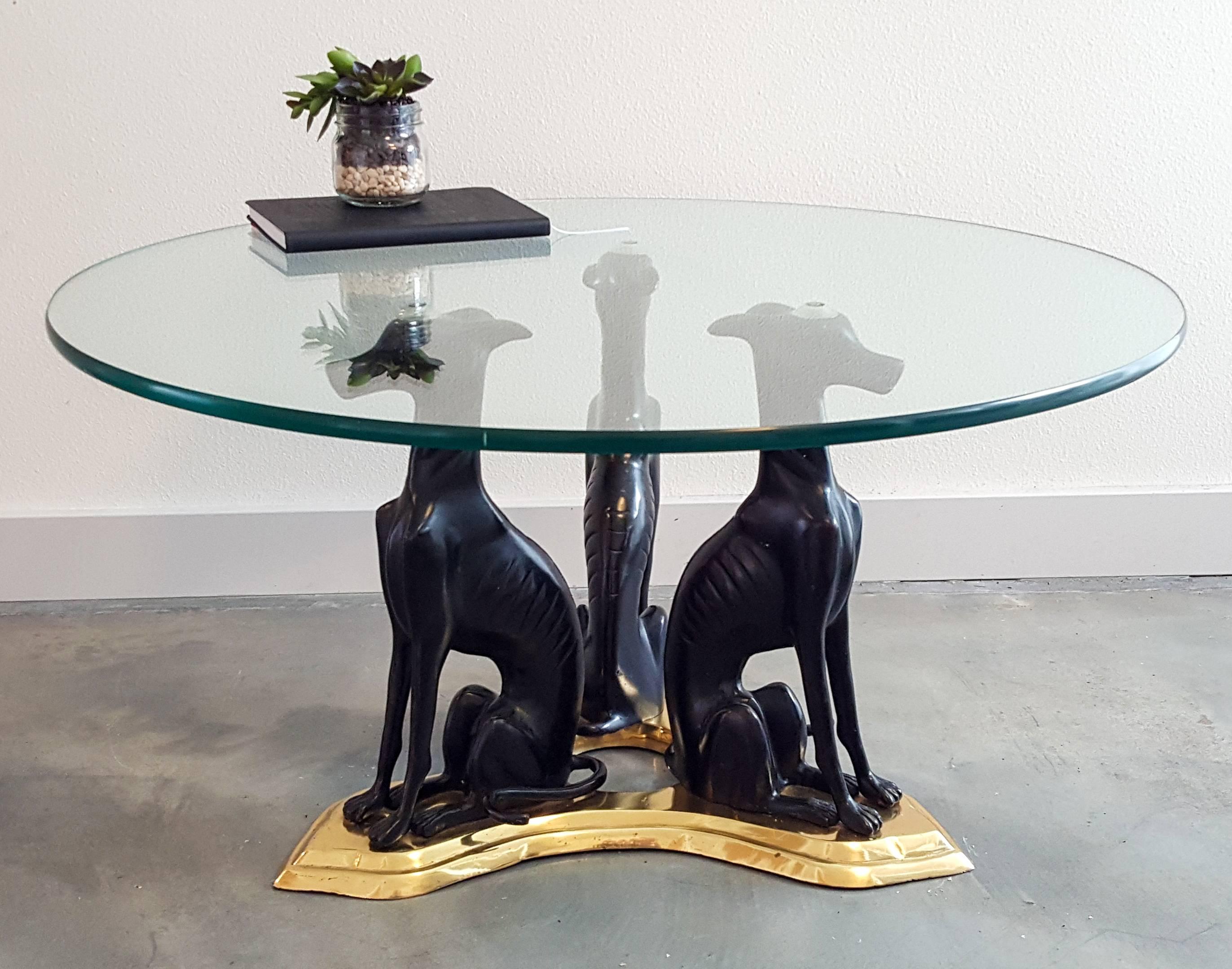 A stunning piece of true Hollywood Regency styling, this Maitland-Smith cocktail or petite coffee table is a show-stopper. The piece features cast bronze whippet or greyhound styled dogs that sit atop a cast brass base.

The piece is in good