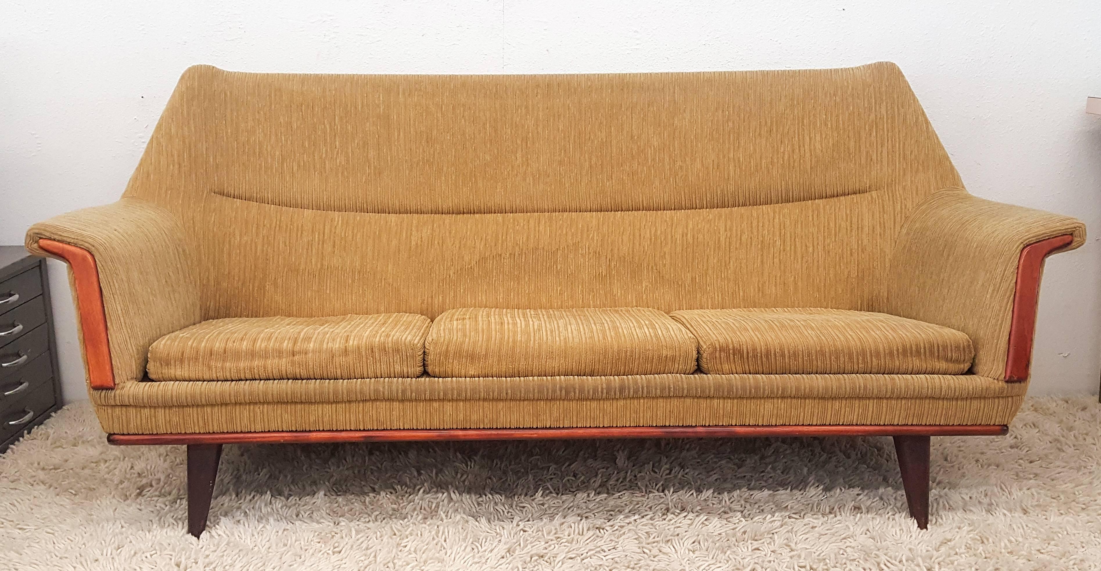 This sofa is absolutely gorgeous. With its clean lines and higher back, the form on this sofa is very reminiscent of Finn Juhl's Poet sofa. The sofa features a teak frame and teak trim and requires reupholstery.