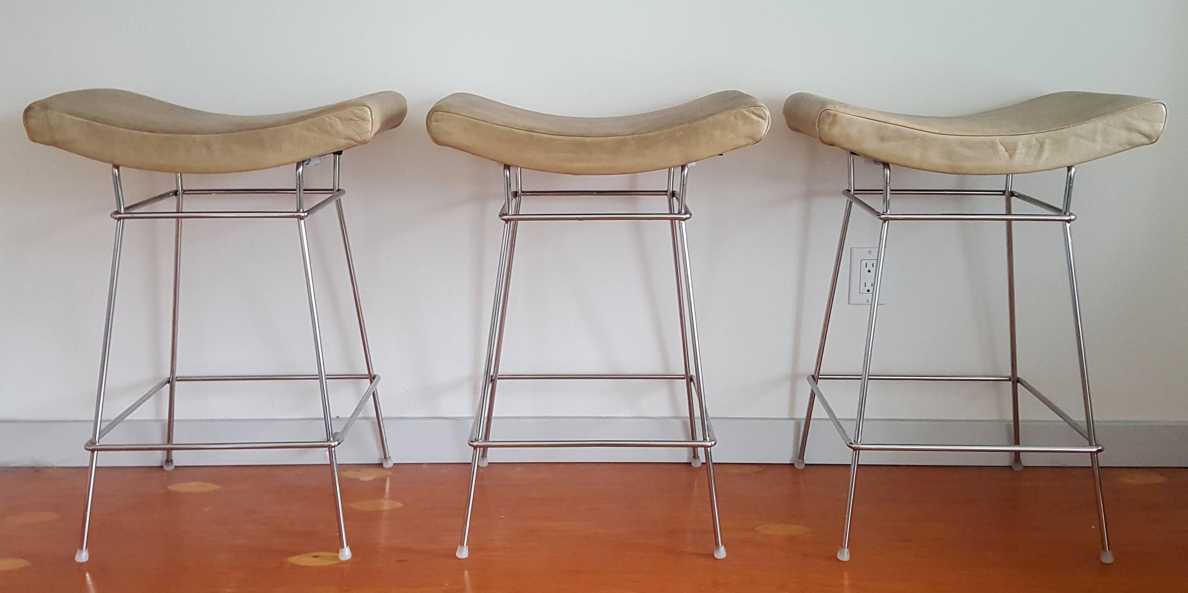 Recipient of the 2002 Brazil Faz award, these counter height bar stools have a super sleek and modern look, while also featuring an interesting distressed/antiqued leather on top. The stools chrome legs are in fantastic condition, with distressed
