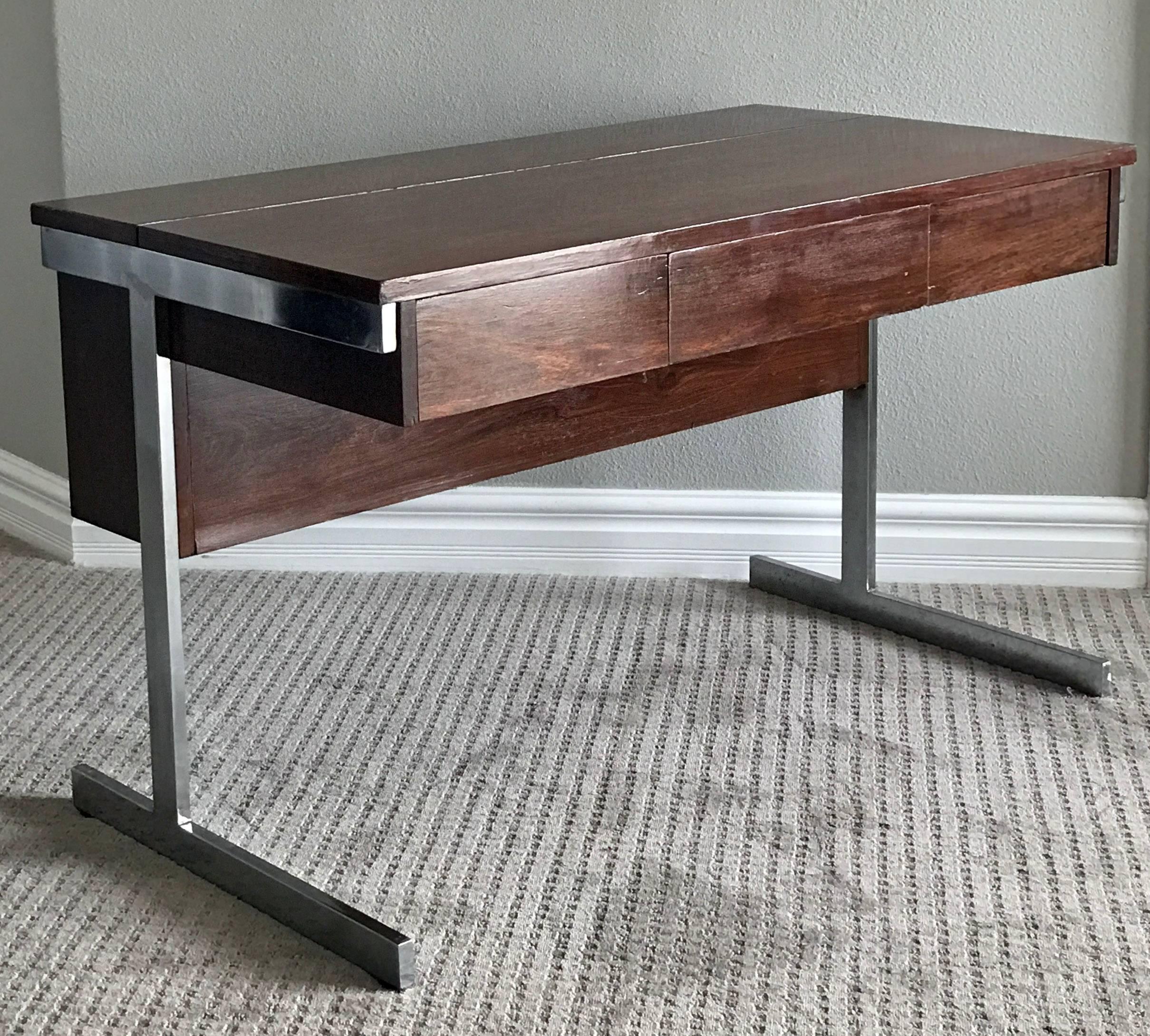 A stunning piece of Mid-Century Modern design; this desk from Lane Furniture company is made of solid rosewood with a light gloss finish. The desk features a flip up compartment for file folders, as well as three drawers in the front and finished