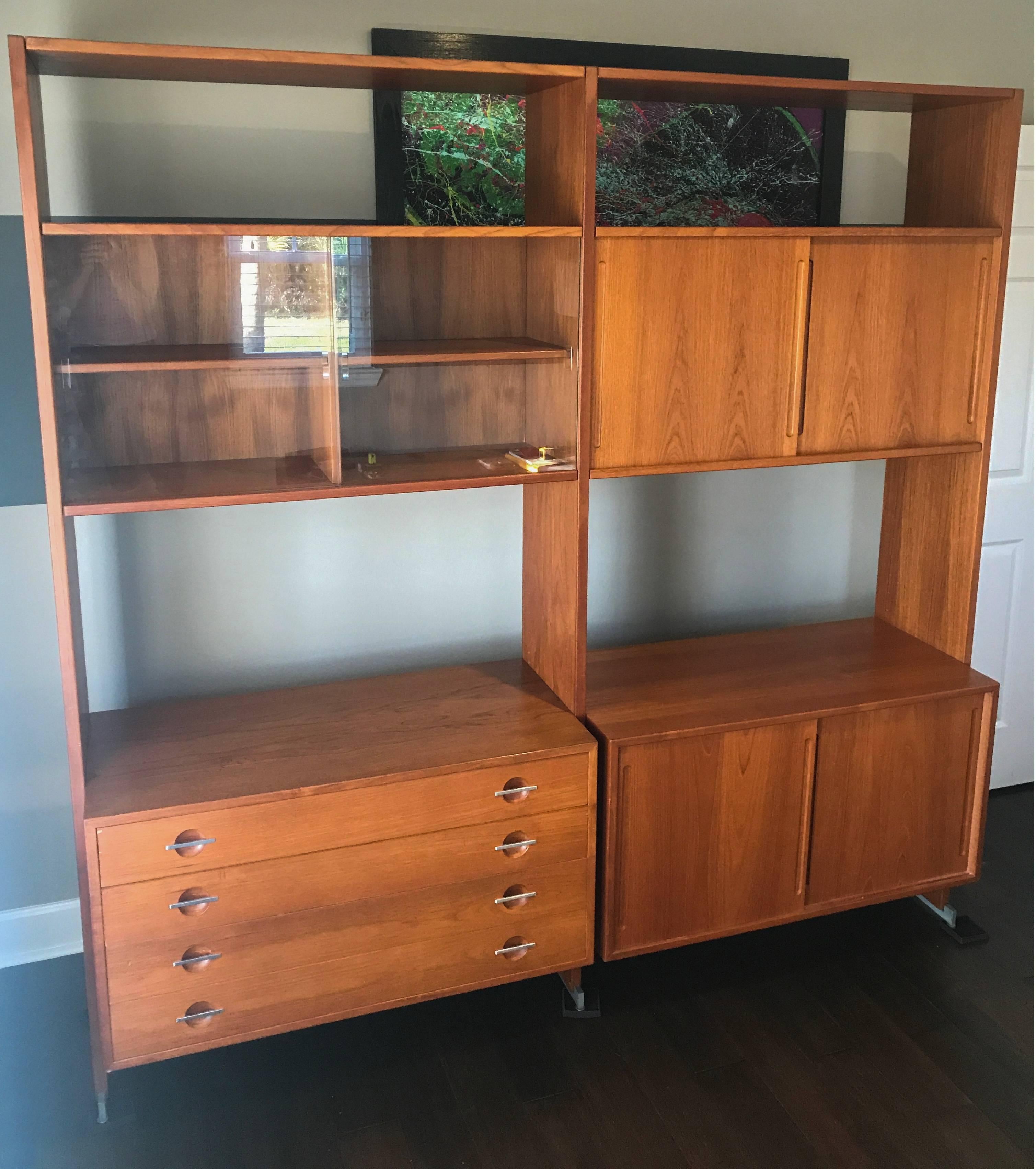 A stunning piece of Mid-Century Modern Danish design. This large teak wall designed by Hans Wegner for Ry Mobler is breathtakingly beautiful. This Hans Wegenr unit is comprised of two large bays, with a total of four cabinets. 

The wall unit is