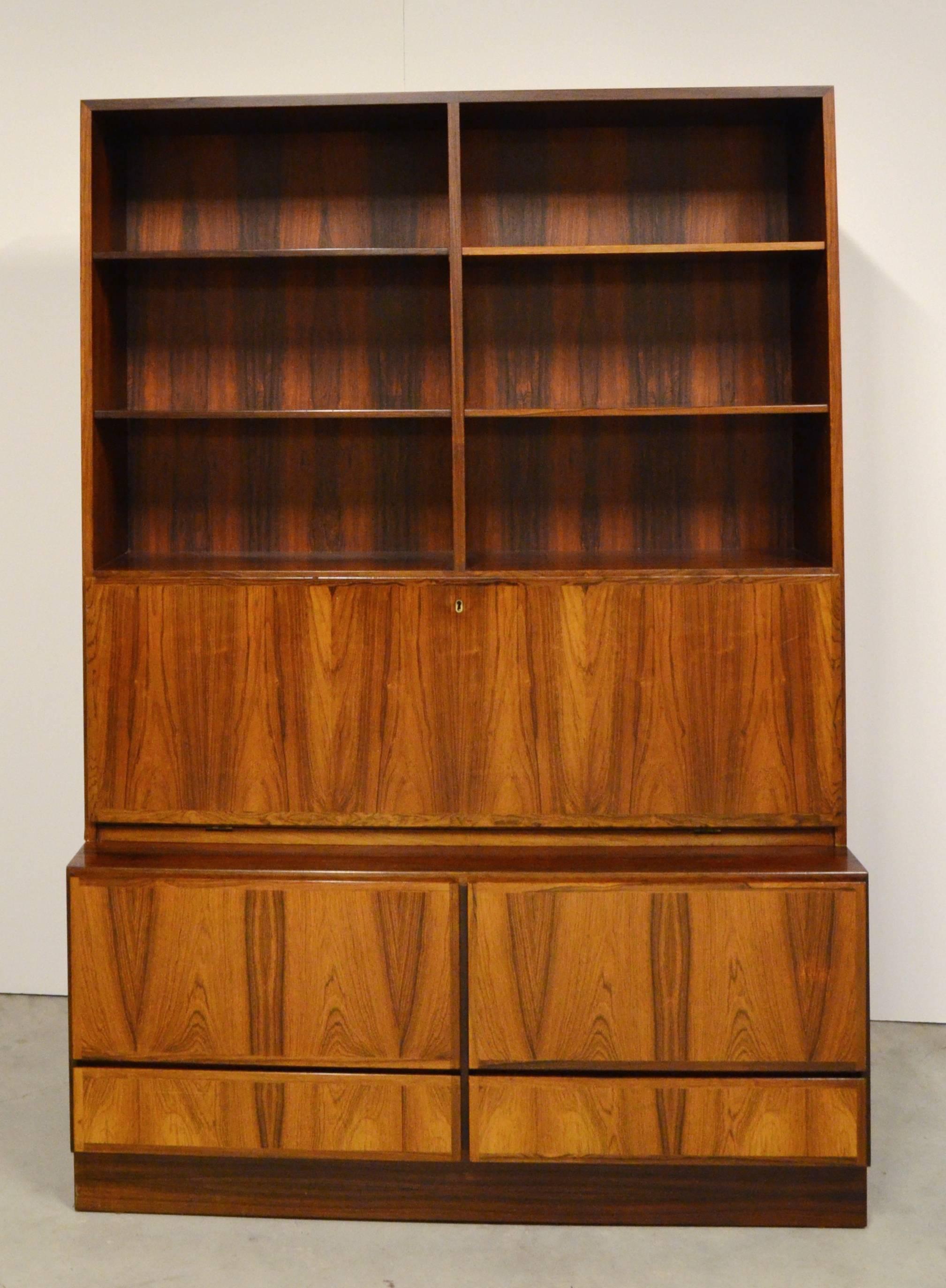 Mid-Century Modern cabinet by Omann Jun Furniture, Denmark, the upper section open has adjustable height shelves over a long hinged door dropping to reveal a fitted interior with shelves and drawers. The lower cabinet has two large drawers over two