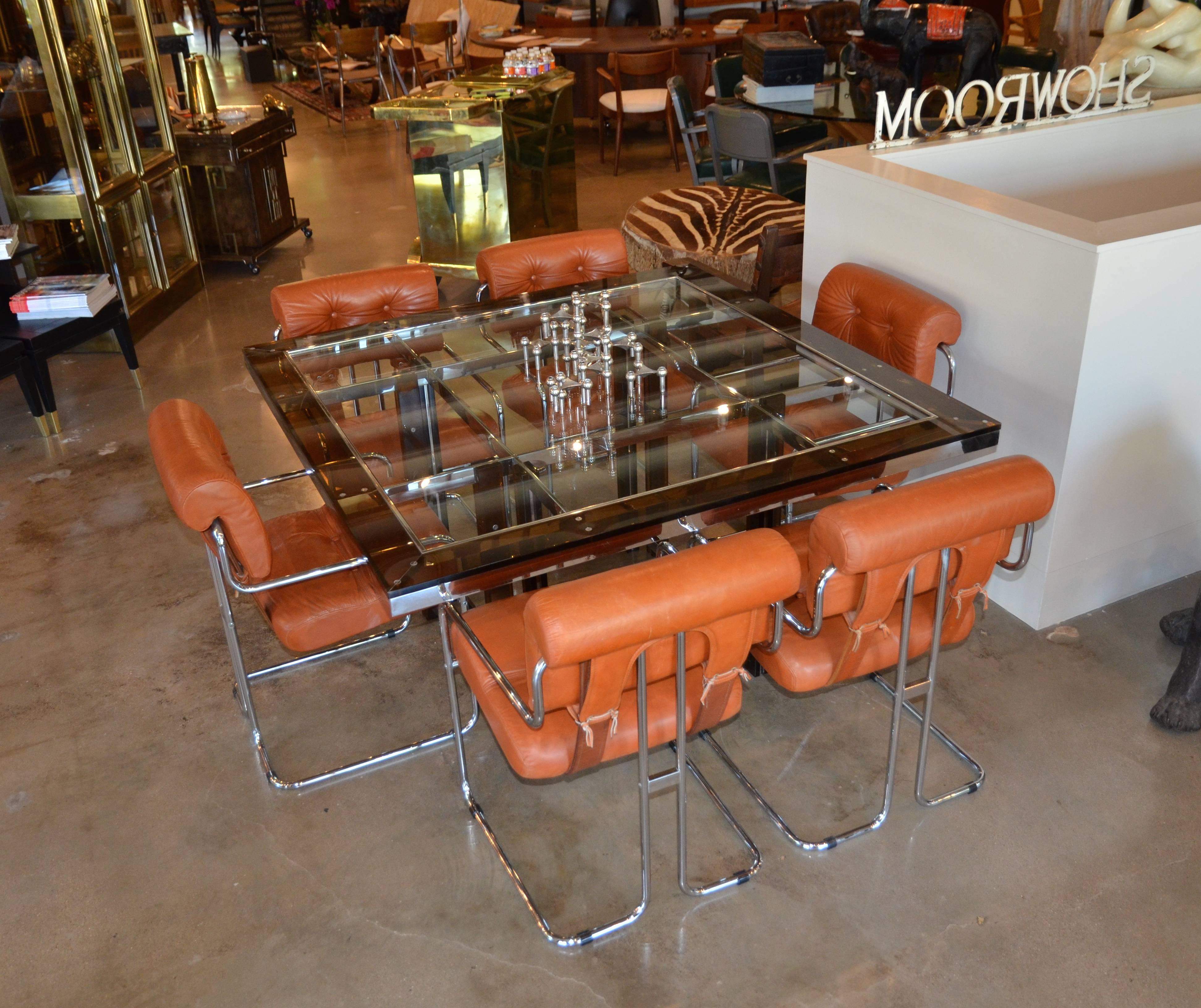 In the style of Charles Hollis Jones and Tobia Scarpa, this unique amber acrylic square dining table has a finely crafted chrome frame and inset glass top. Exposed chrome fasteners where chrome and acrylic is joined. 
