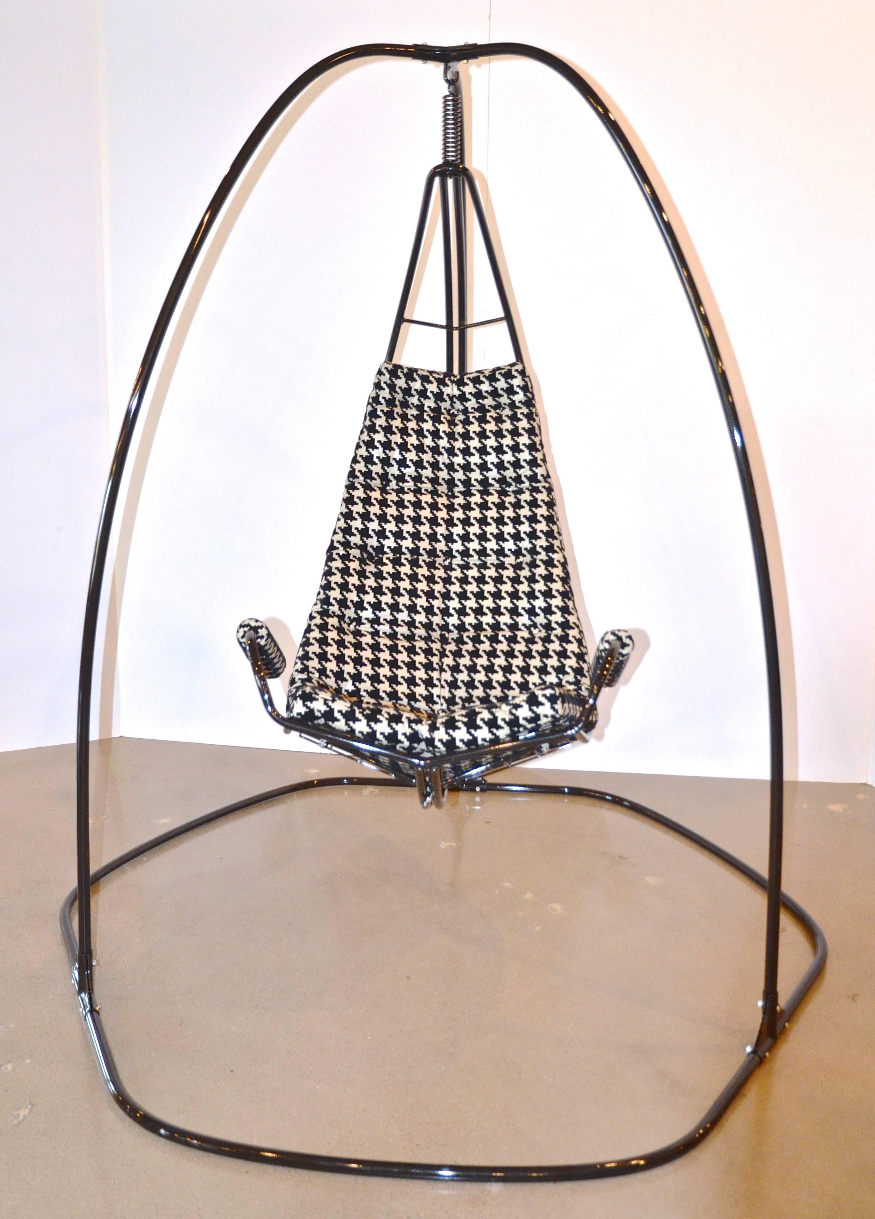 Crazy cool swing or lounge chair, fully restored, originally by Homecrest. Newly powder coated steel frame holds generous and comfortable armed chair. Newly remade cushion in large-scale flocked vinyl houndstooth of black and beige. circa 1970.