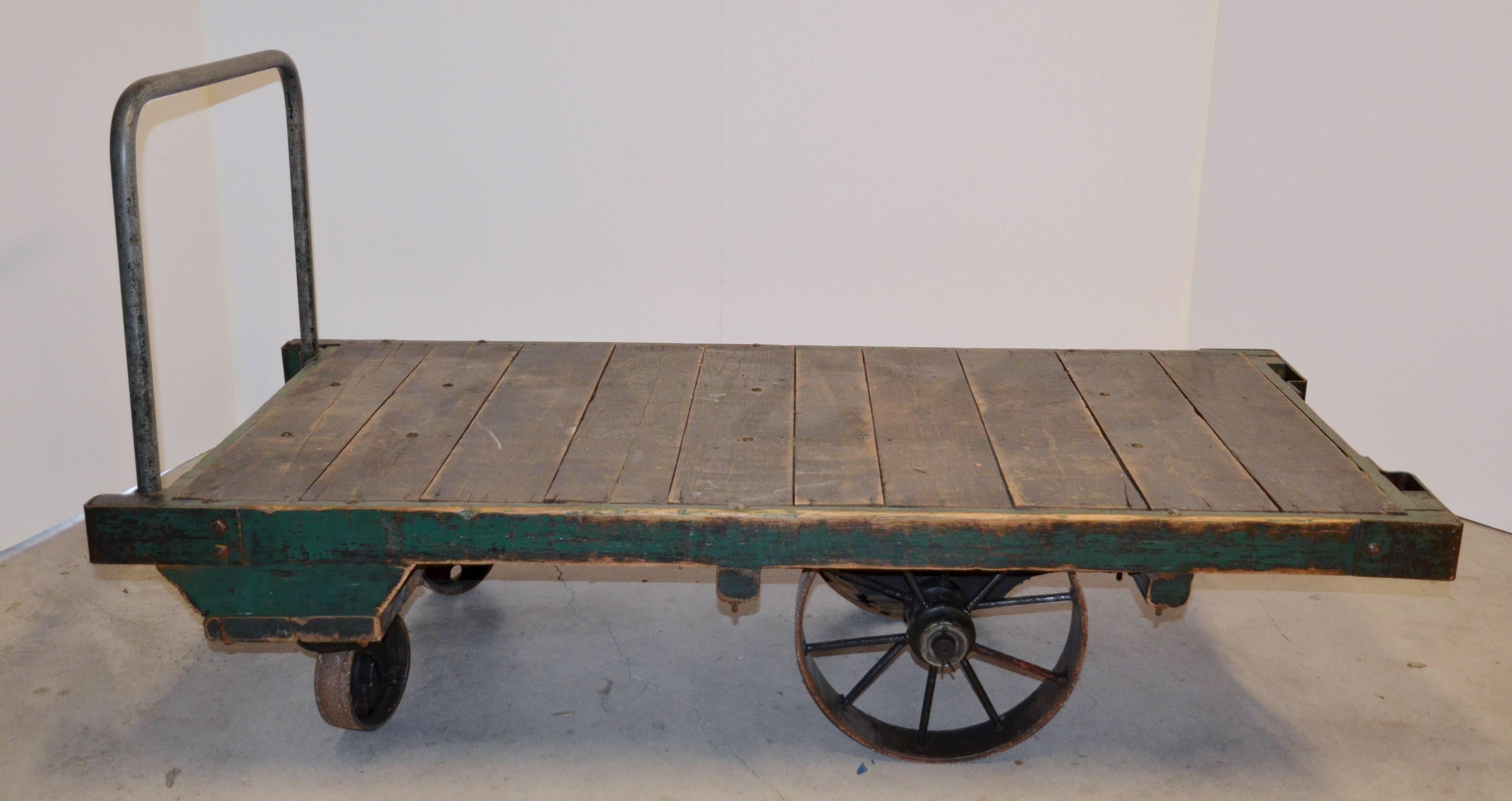 Large scale cart from a Mid-west factory makes a cool industrial cocktail table.  Four opersteel wheels and painted wood top, all original.  Removable handle (see photos).  Without the handle the cart height is 19